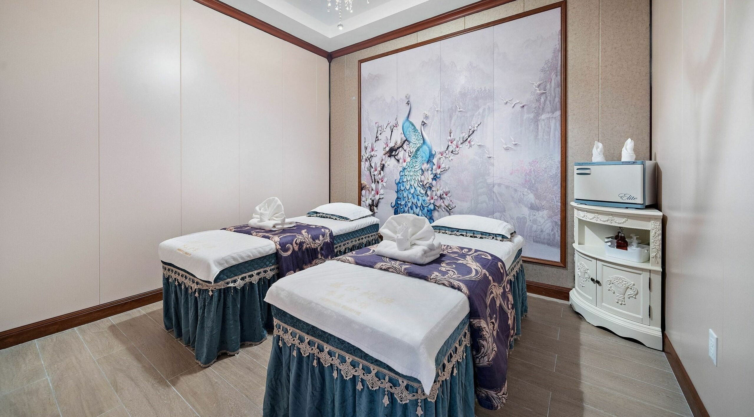 Relaxing dual massage beds at Prosperous Paradise Spa in Houston, Texas, US with elegant peacock artwork.