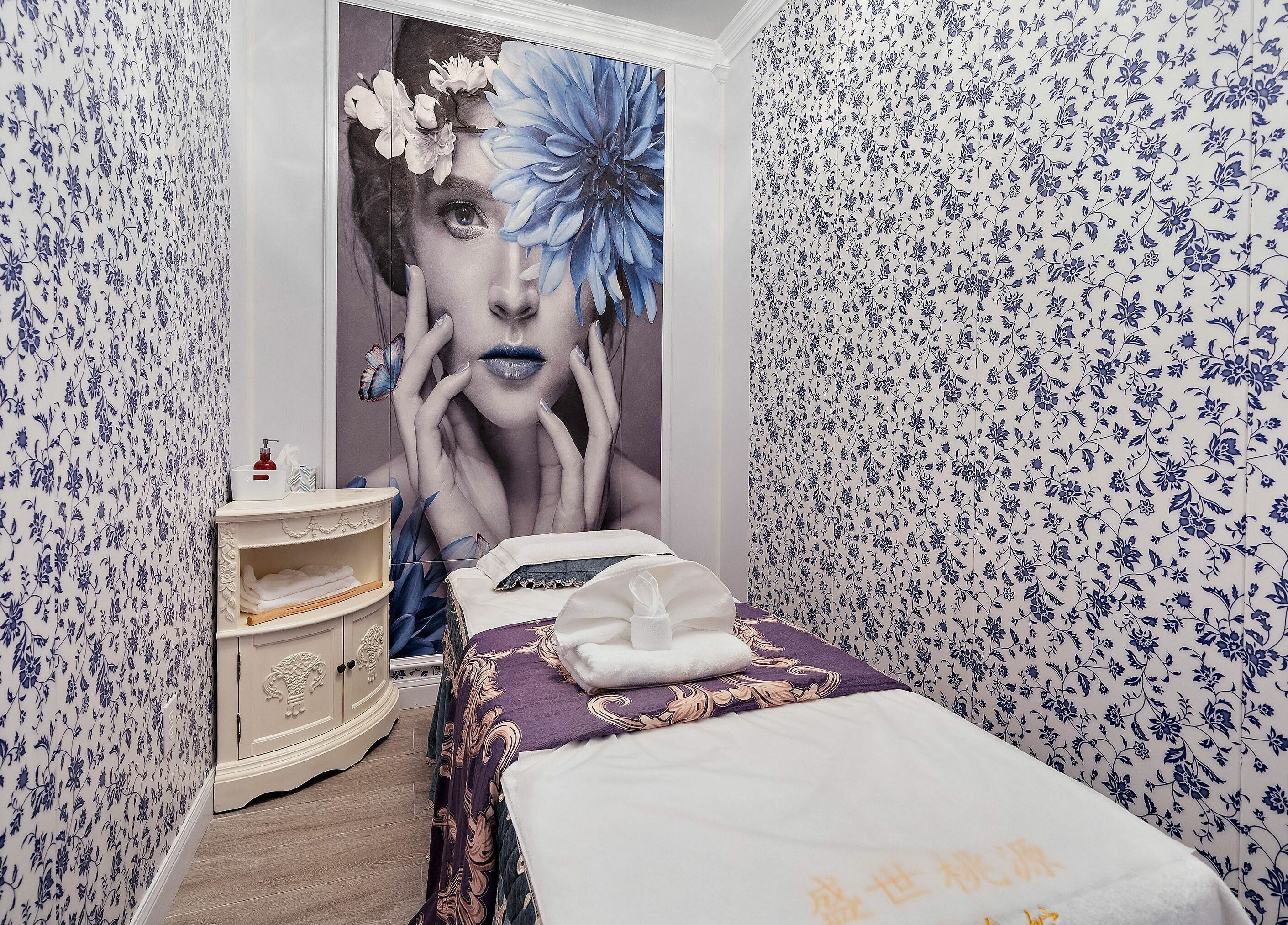 Tranquil treatment room at Prosperous Paradise Spa, Houston, Texas, US, with floral decor and plush massage table.