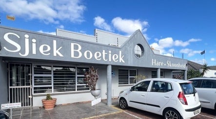 Front view of Mariska Salon Sjiek Boetiek, Cape Town, Western Cape, ZA. Modern facade with cars parked.