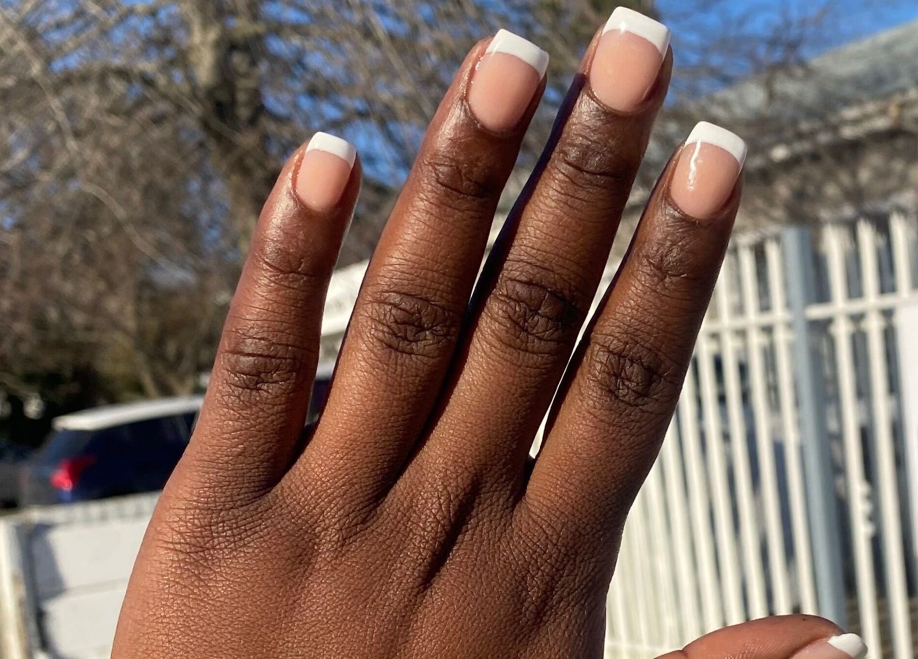 Hand with elegant French manicure outside Nail & Beauty Creations, Cape Town, Western Cape, ZA.