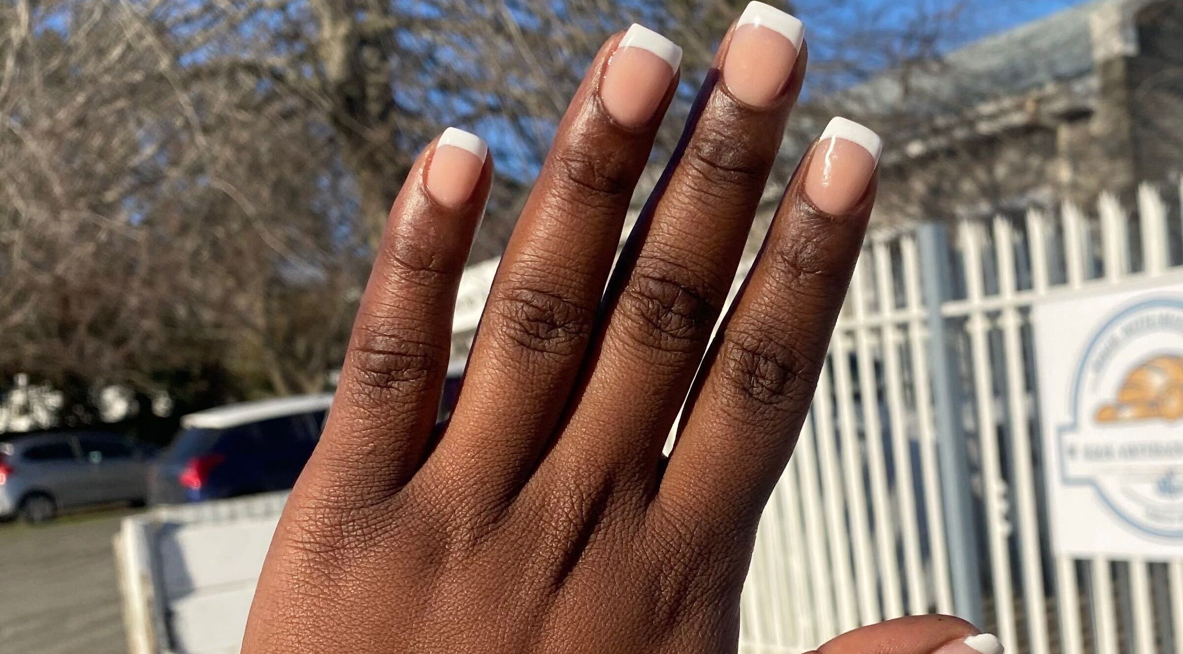Hand with elegant French manicure outside Nail & Beauty Creations, Cape Town, Western Cape, ZA.