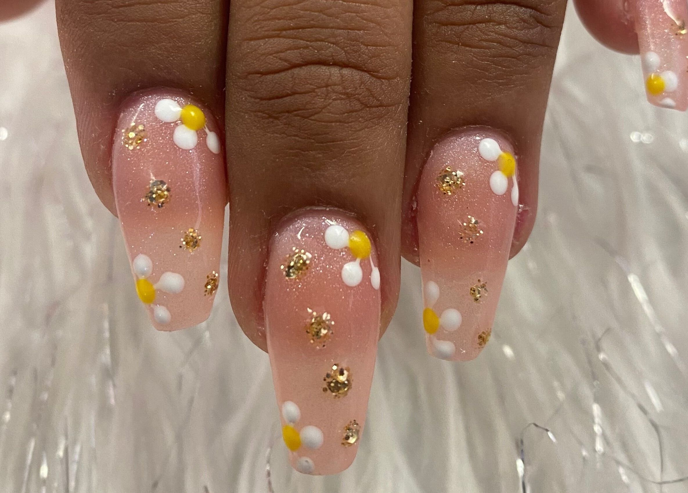 Elegant floral nail art with daisies and gold glitter at Nail & Beauty Creations, Cape Town, Western Cape, ZA.