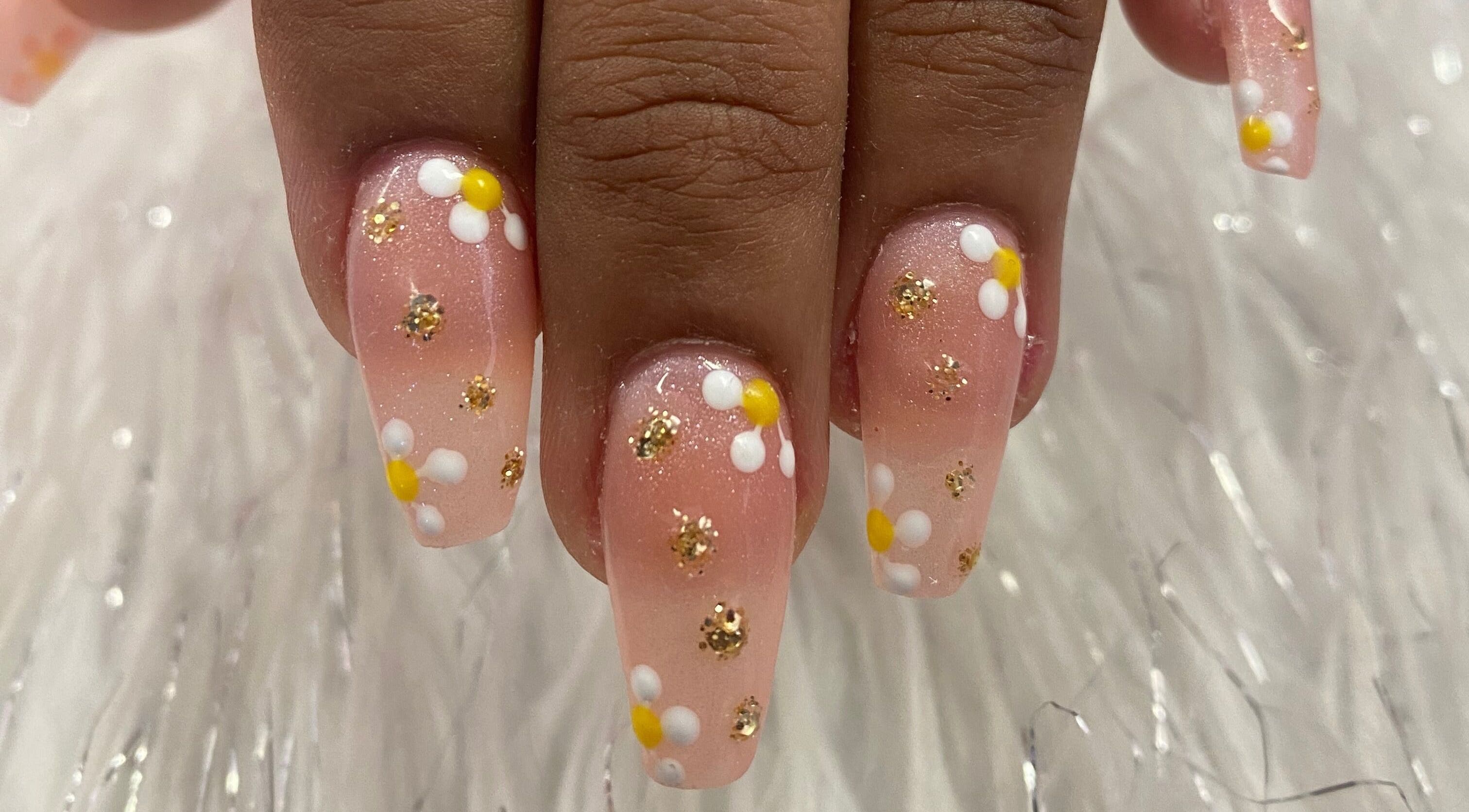 Elegant floral nail art with daisies and gold glitter at Nail & Beauty Creations, Cape Town, Western Cape, ZA.