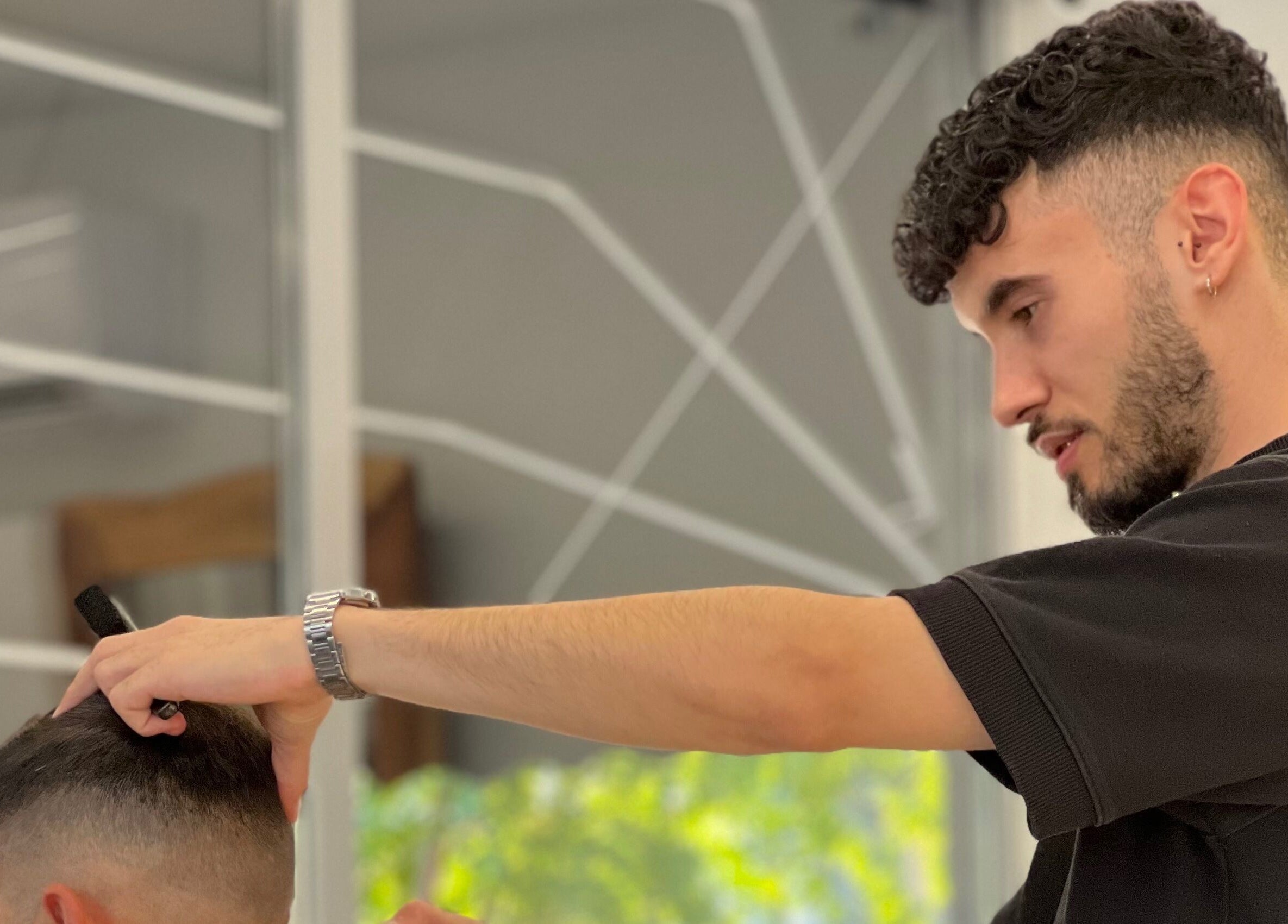 Κομμωτής στο Diamantopoulos Barbershop- Ilion, Ίλιον, GR, δημιουργεί μοντέρνο ανδρικό κούρεμα.