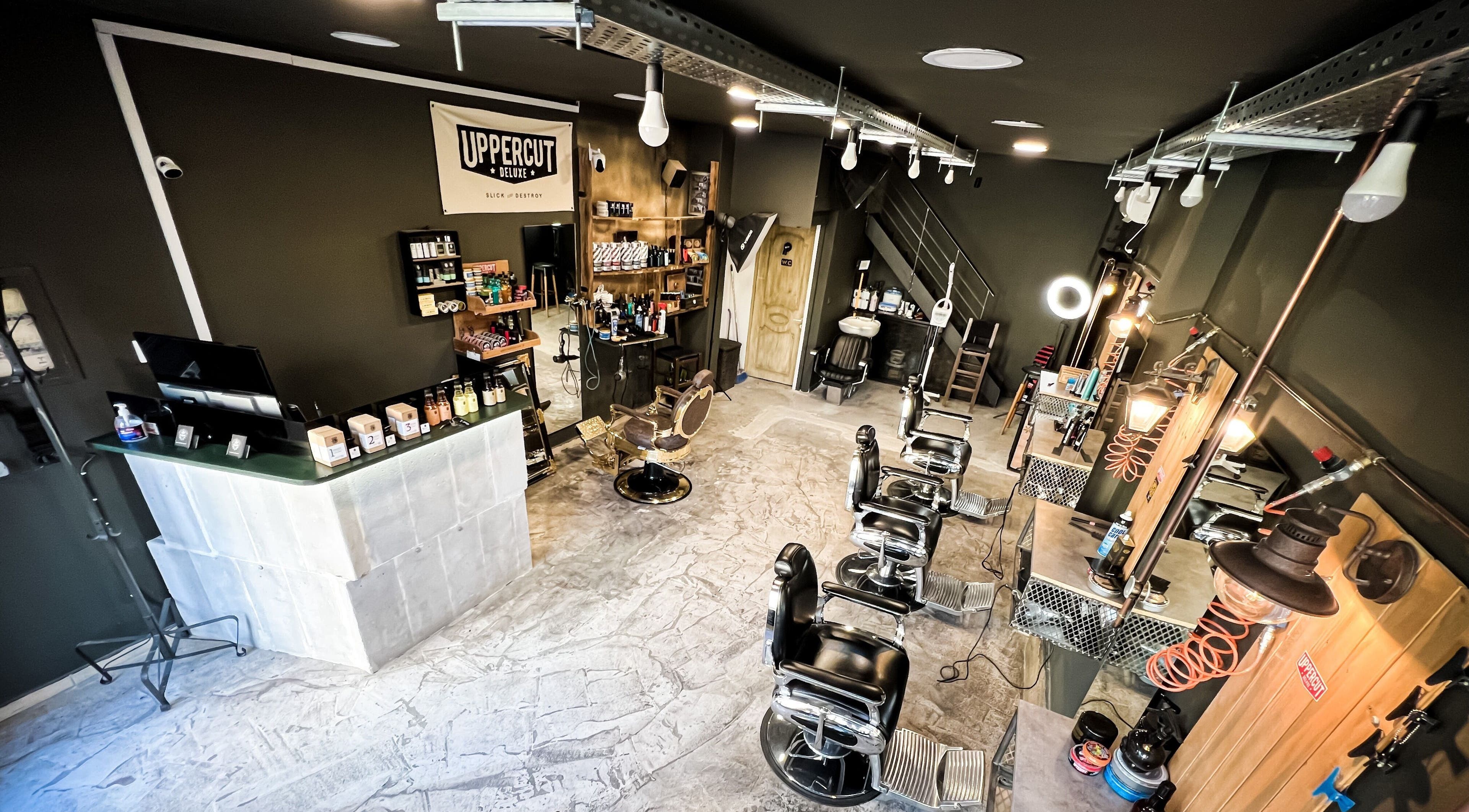 Φωτεινό εσωτερικό του Diamantopoulos Barbershop Kamatero στην Καματερό, GR με καρέκλες και εργαλεία περιποίησης.