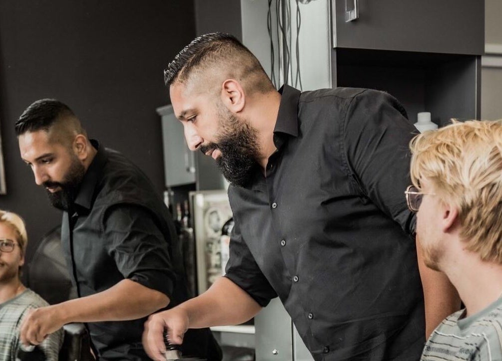 Skilled barber at The Barberchop, Cape Town, Western Cape, ZA, styling client's hair with precision.