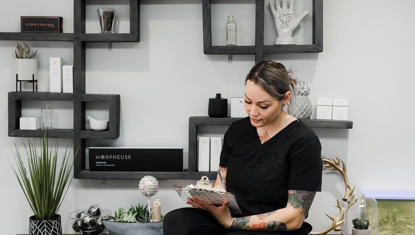 Staff member at Jem Medical Strathroy - Dose of Elegance in Strathroy, Ontario, CA sitting by modern decor.