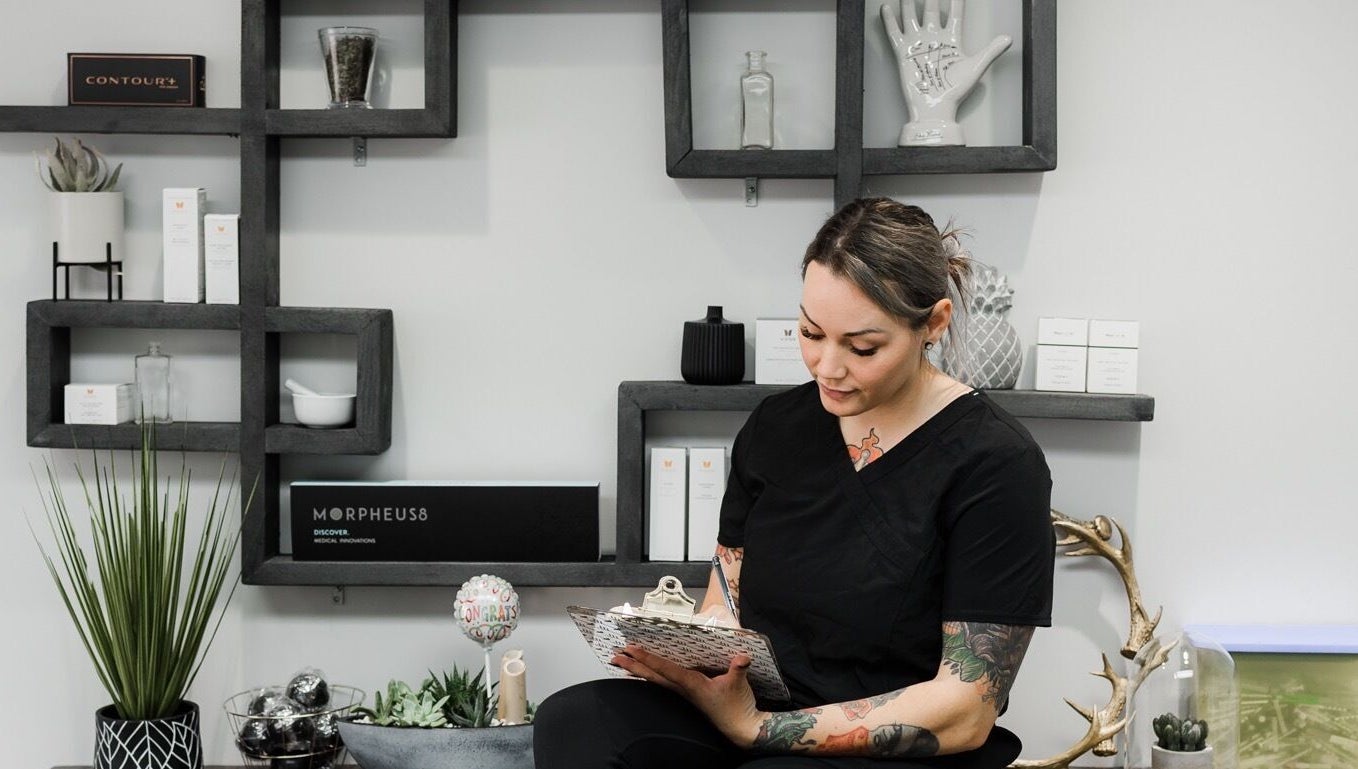 Staff member at Jem Medical Strathroy - Dose of Elegance in Strathroy, Ontario, CA sitting by modern decor.