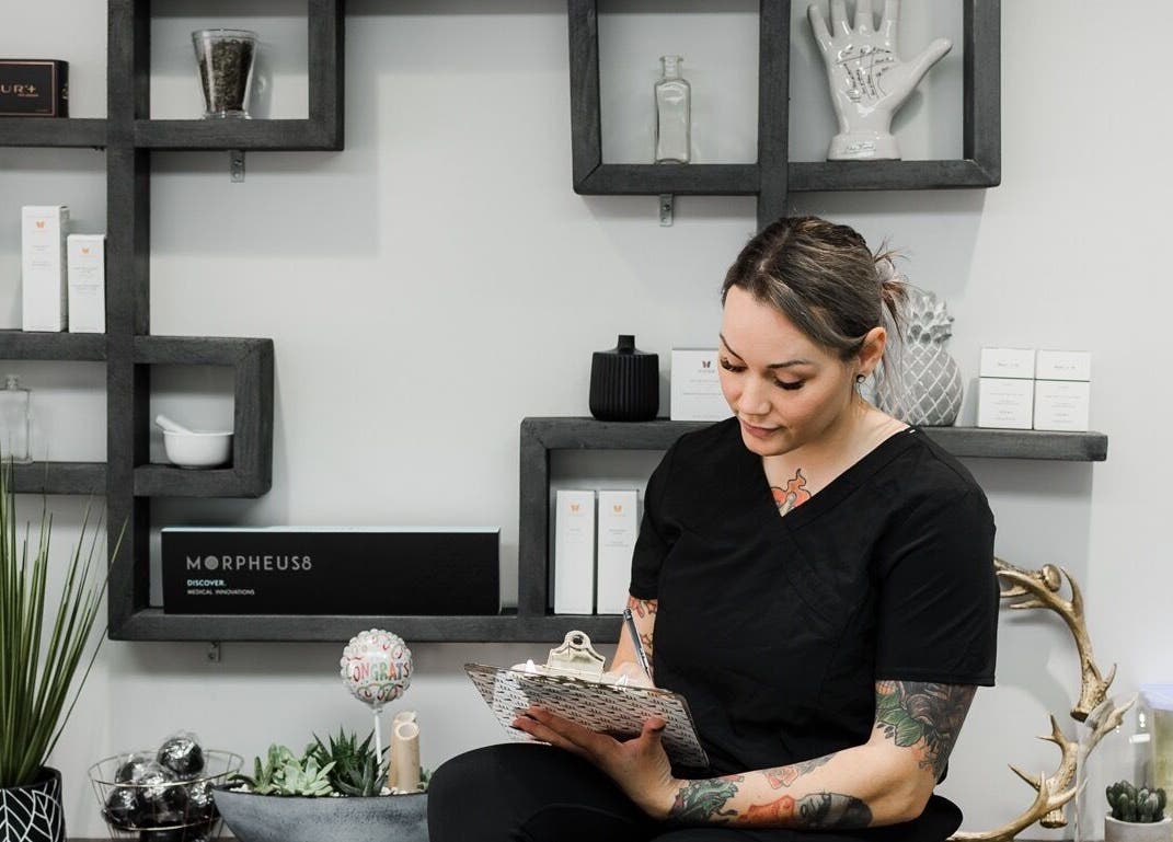 Staff member at Jem Medical Strathroy - Dose of Elegance in Strathroy, Ontario, CA sitting by modern decor.
