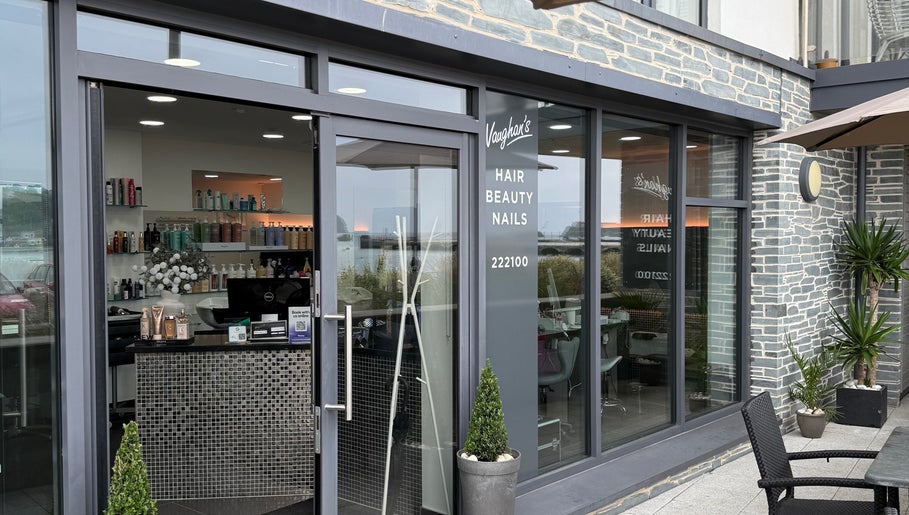 Front entrance of Vaughan's Hair and Beauty in Plymouth, England, featuring stylish decor and visible products.