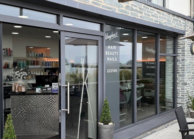 Front entrance of Vaughan's Hair and Beauty in Plymouth, England, featuring stylish decor and visible products.