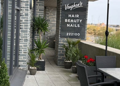 Entrance to Vaughan's Hair and Beauty in Plymouth, England, GB, with stylish decor and outdoor seating.