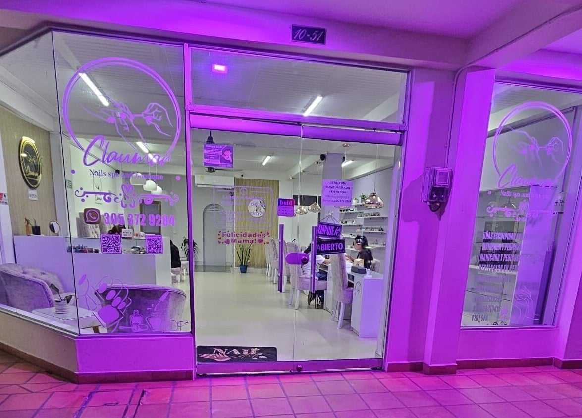 Fachada iluminada de Claumar Nails Spa en La Dorada, Caldas, BR, destacando su entrada acogedora.
