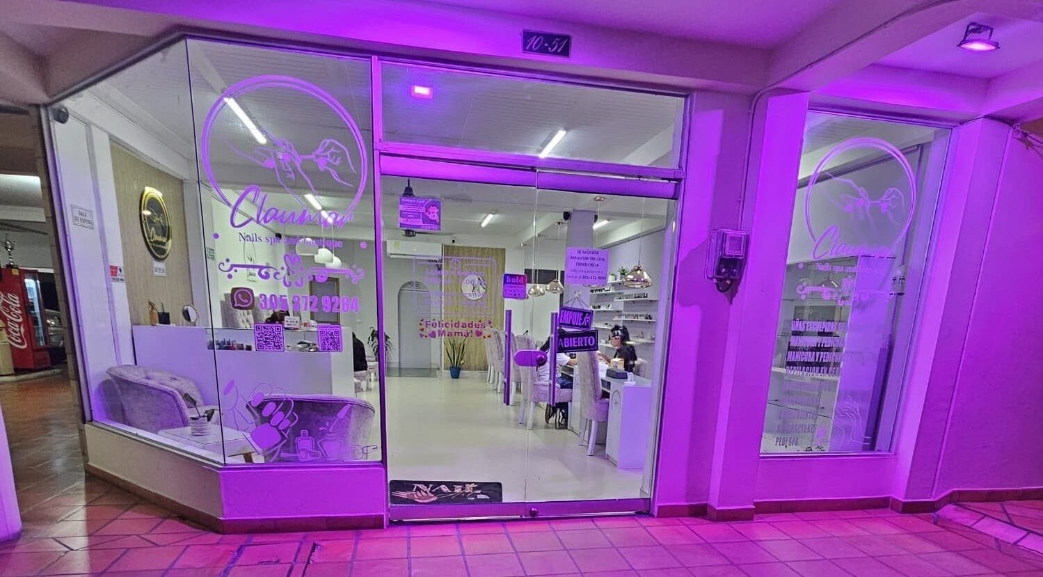 Fachada iluminada de Claumar Nails Spa en La Dorada, Caldas, BR, destacando su entrada acogedora.