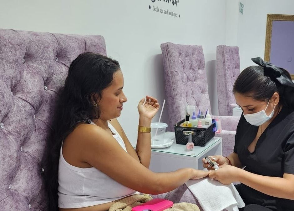 Profesional realizando manicura en Claumar Nails Spa, La Dorada, Caldas, BR, con decoración lujosa.