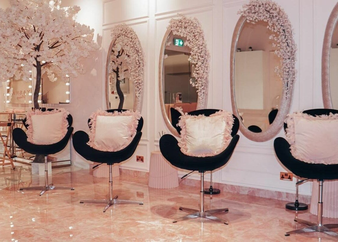 Luxurious interior of Yasna Beauty Salon, Dubai, AE with chic seating and decorative mirrors.