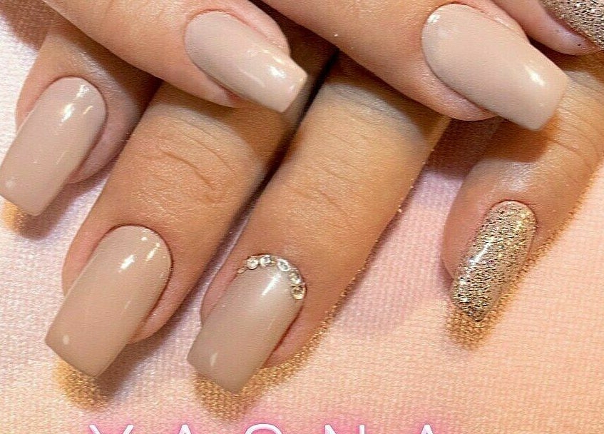 Chic manicured nails with nude and glitter design at Yasna Beauty Salon, Dubai, AE.