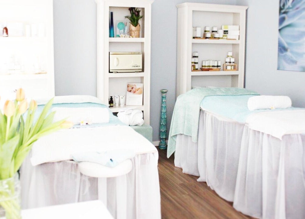 Relaxing spa room at The Garden Spa in Plettenberg Bay, Western Cape, ZA with massage tables and fresh flowers.