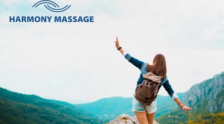 Harmony Massage Bothell logo over mountain view in Bothell, Washington, US, with a woman embracing nature.