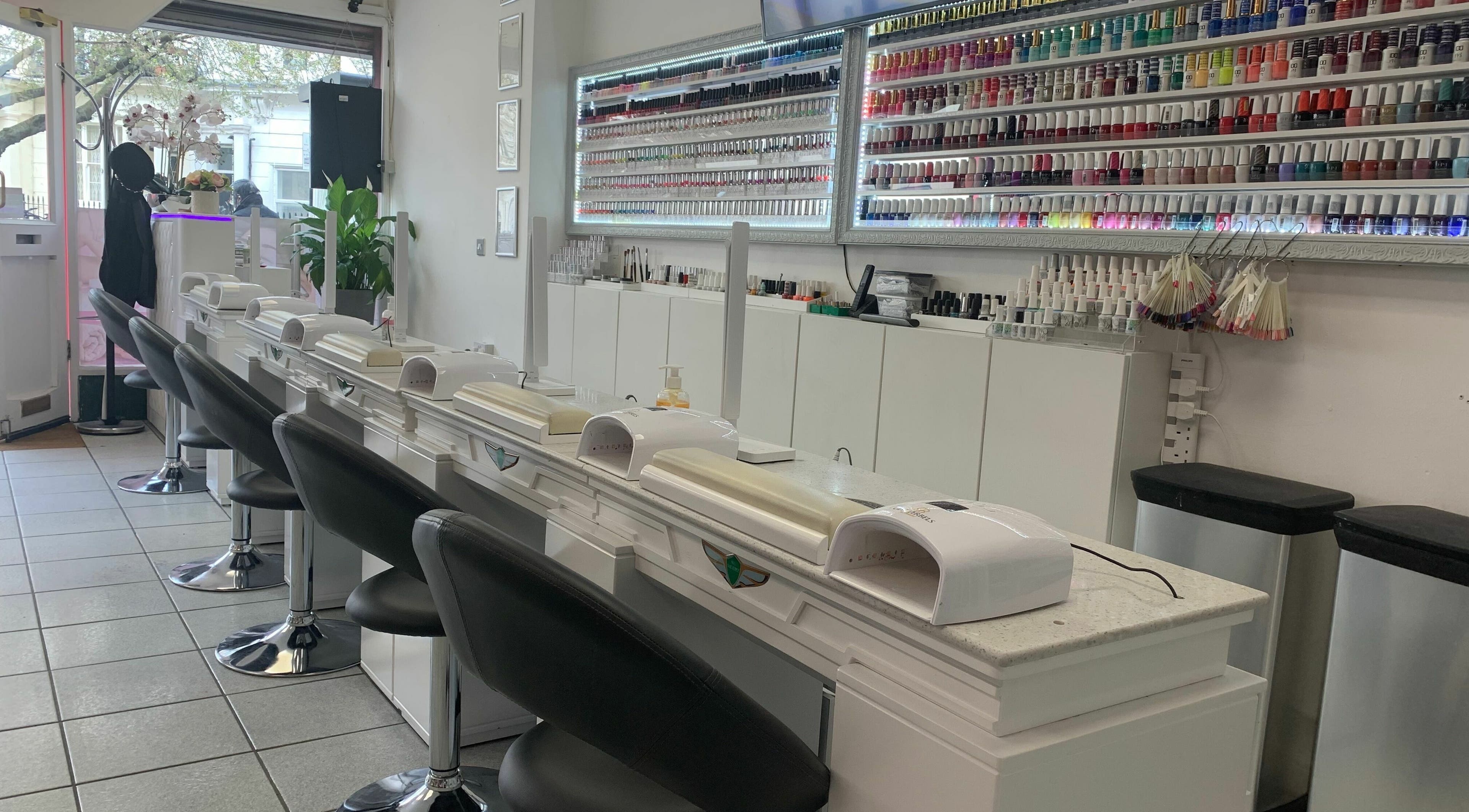 Modern nail stations at Pimlico Nail Bar, London, England, GB, featuring extensive polish selection.