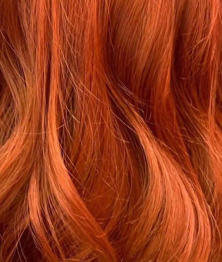 Vibrant red curls styled at Clara Devlin Hair, Cardington, England, GB, showcasing rich color and texture.