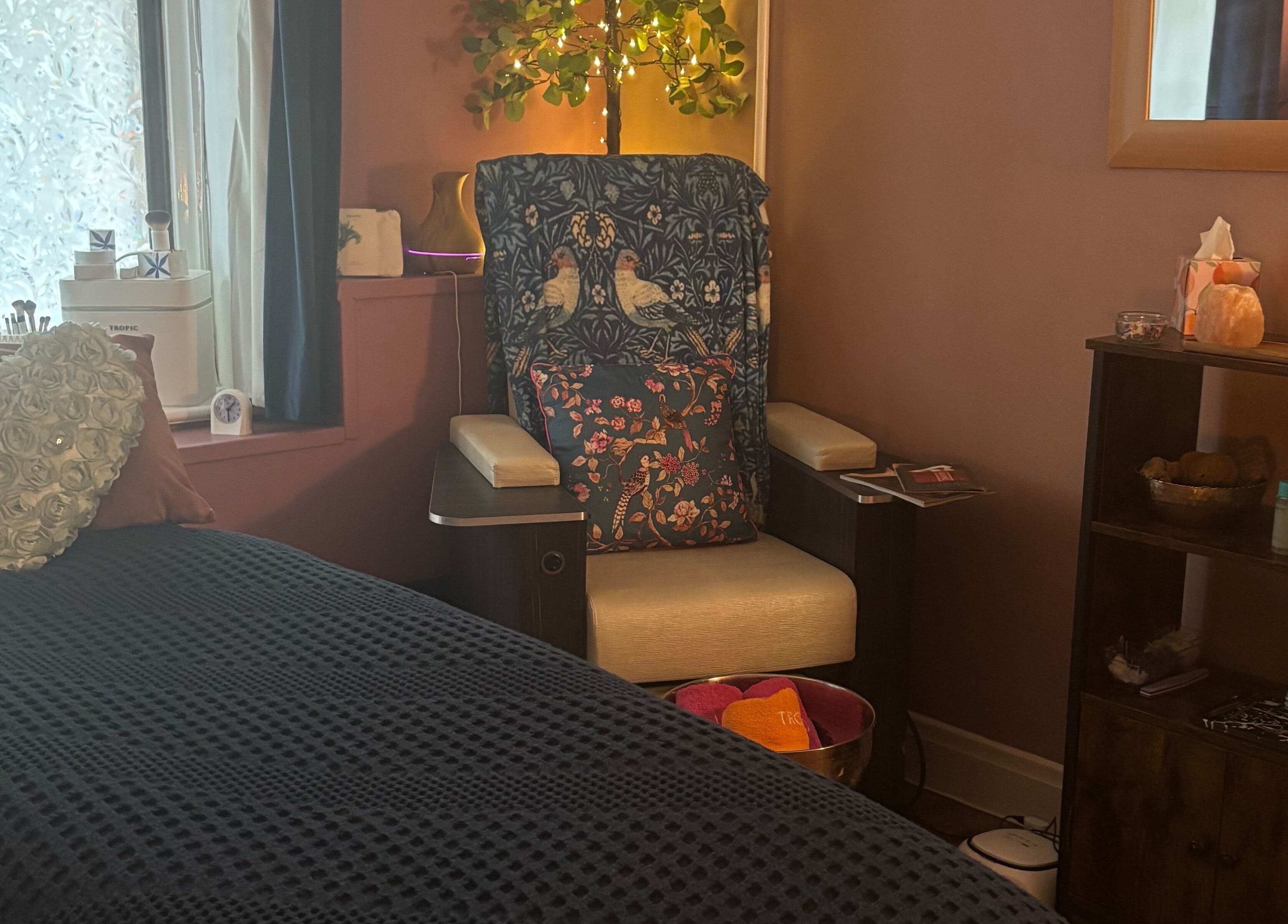 Relaxing corner at Beauty By The Quay, Ramsey, Isle of Man, IM, featuring a plush chair and heart-shaped cushion.