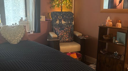 Relaxing corner at Beauty By The Quay, Ramsey, Isle of Man, IM, featuring a plush chair and heart-shaped cushion.