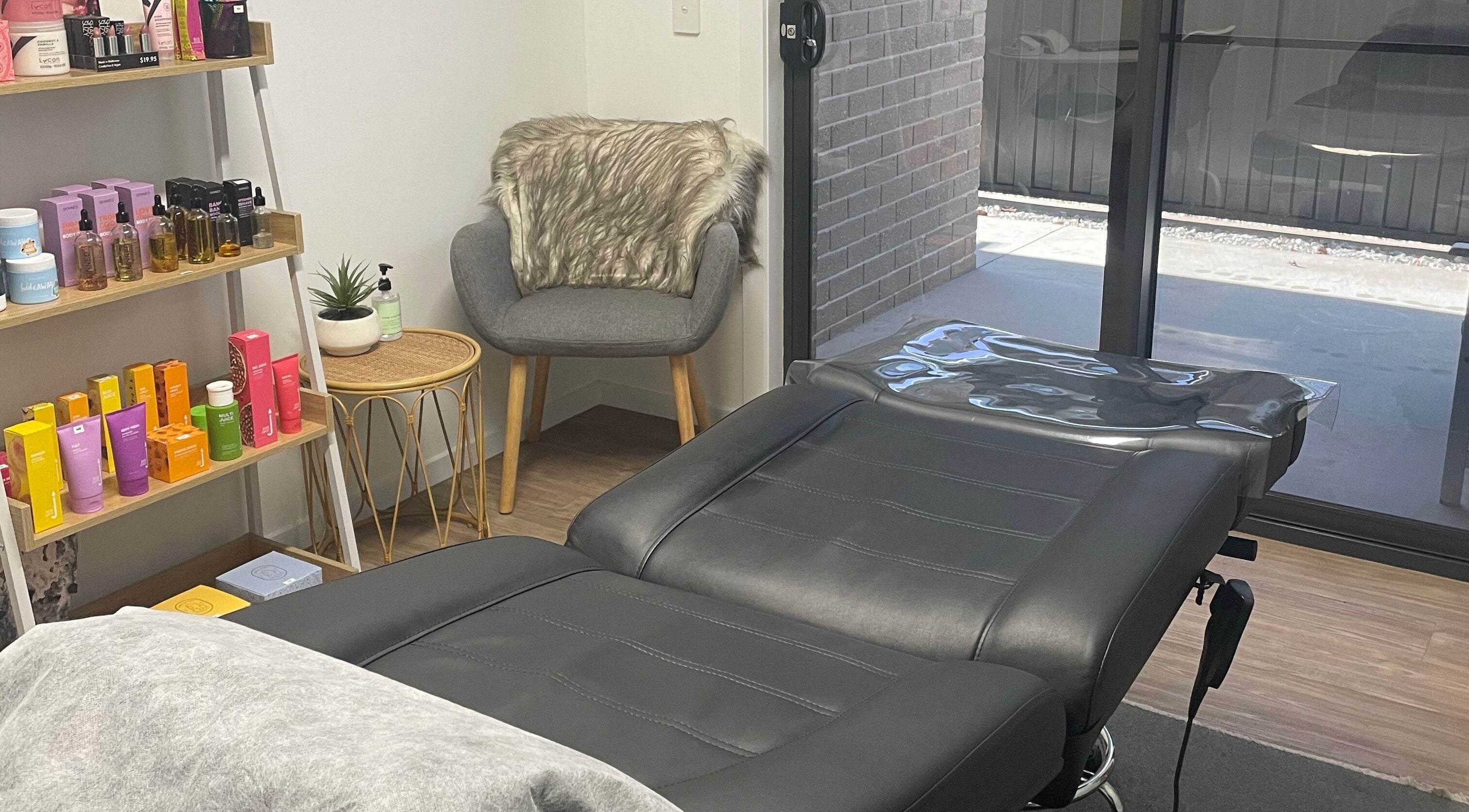 Cozy treatment room at Beauty On Gerrand, Latrobe, Tasmania, AU, with skincare products and a plush chair.