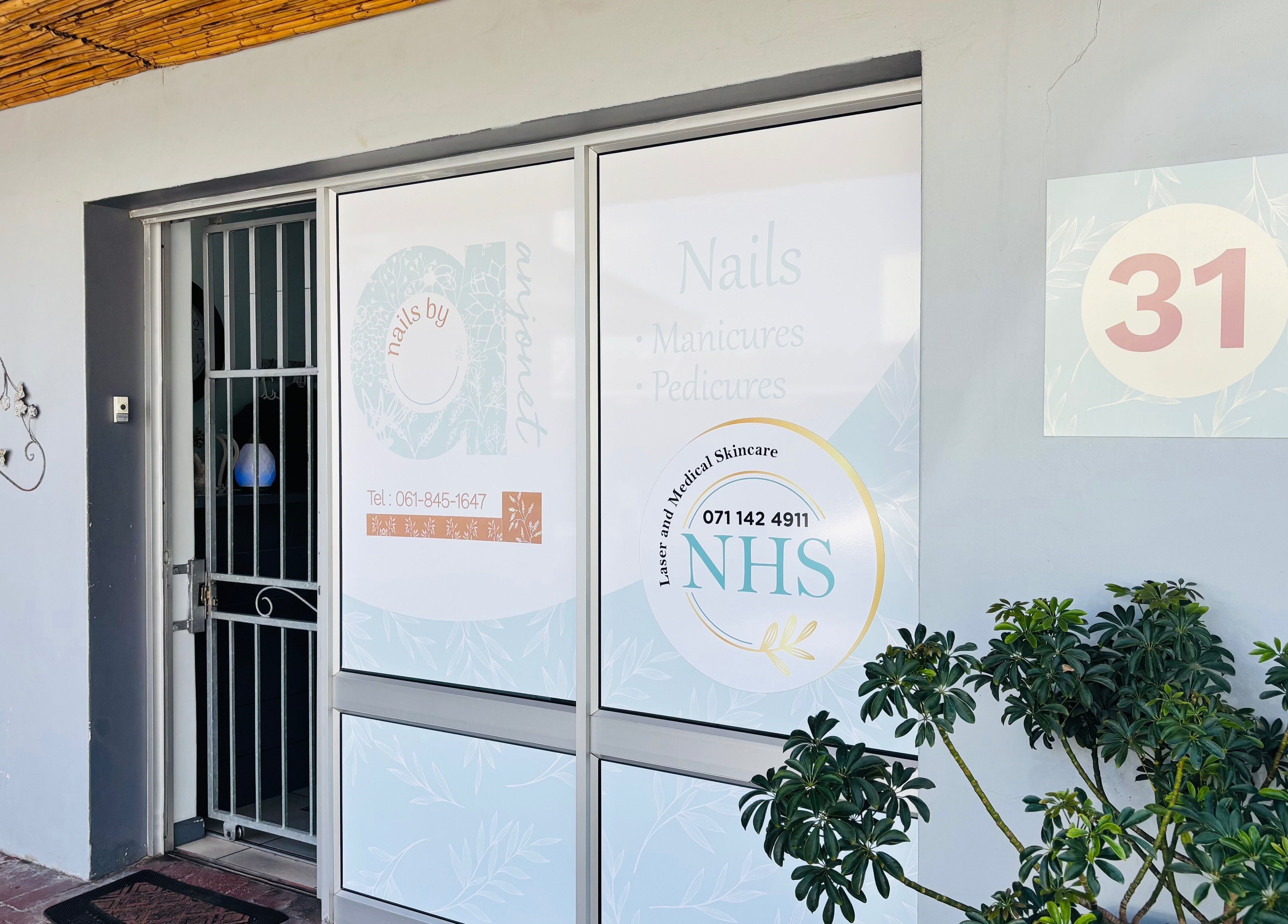 Front of Nails by Anjonet, George, Western Cape, ZA with elegant signage and lush plants.