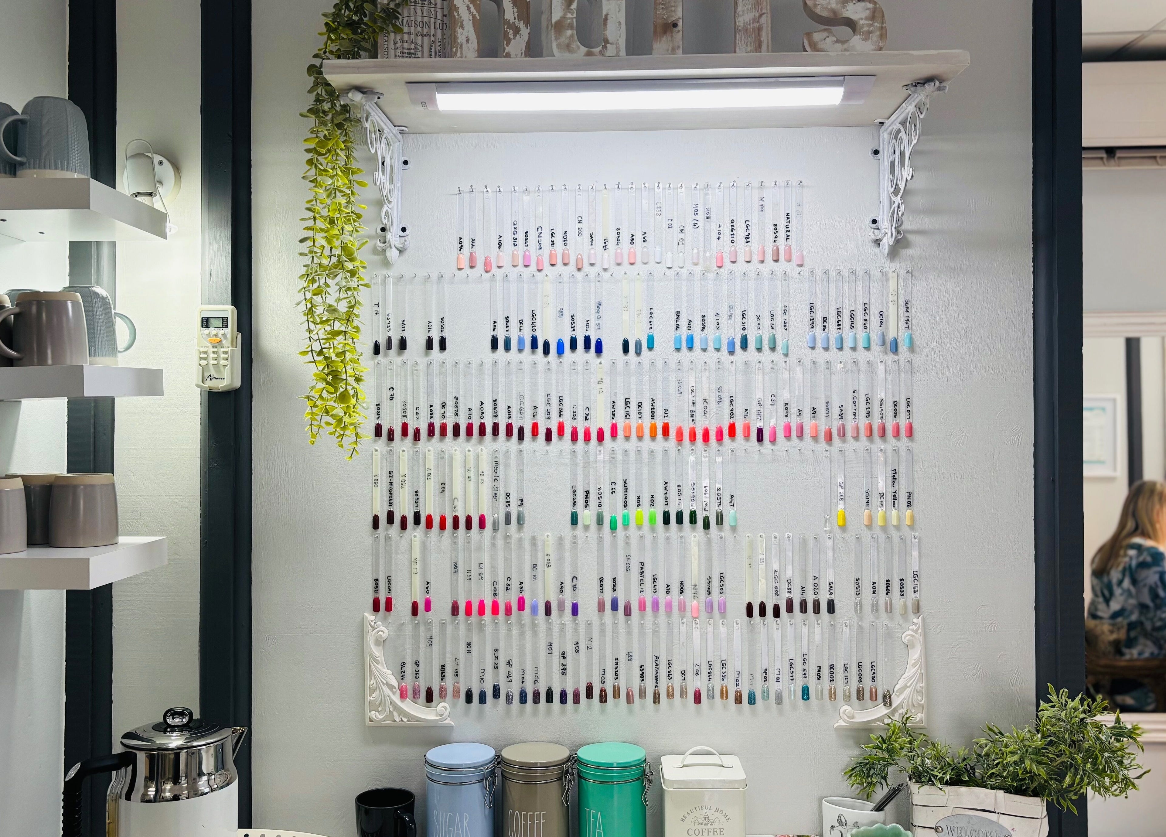 Colorful nail polish display at Nails by Anjonet in George, Western Cape, ZA, with cozy interior elements.