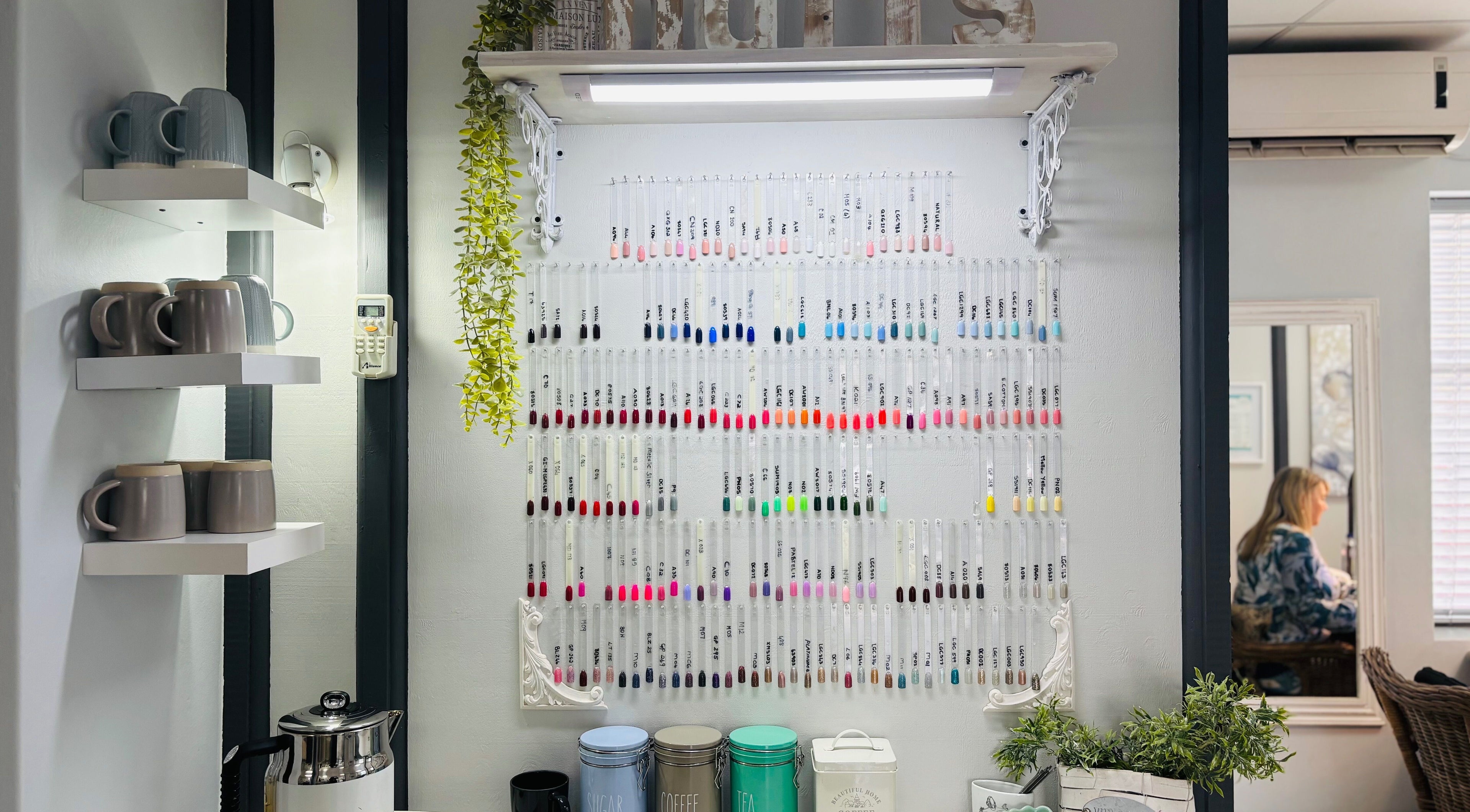 Colorful nail polish display at Nails by Anjonet in George, Western Cape, ZA, with cozy interior elements.