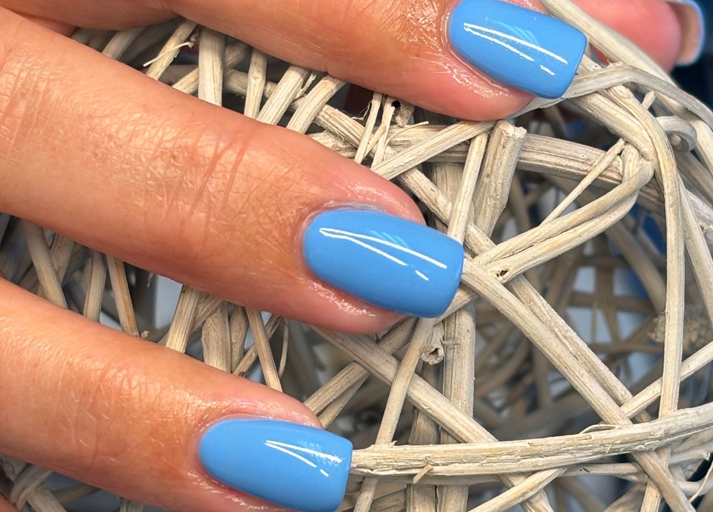 Stylish blue nails holding a wicker ball at Nails by Anjonet, George, Western Cape, ZA.