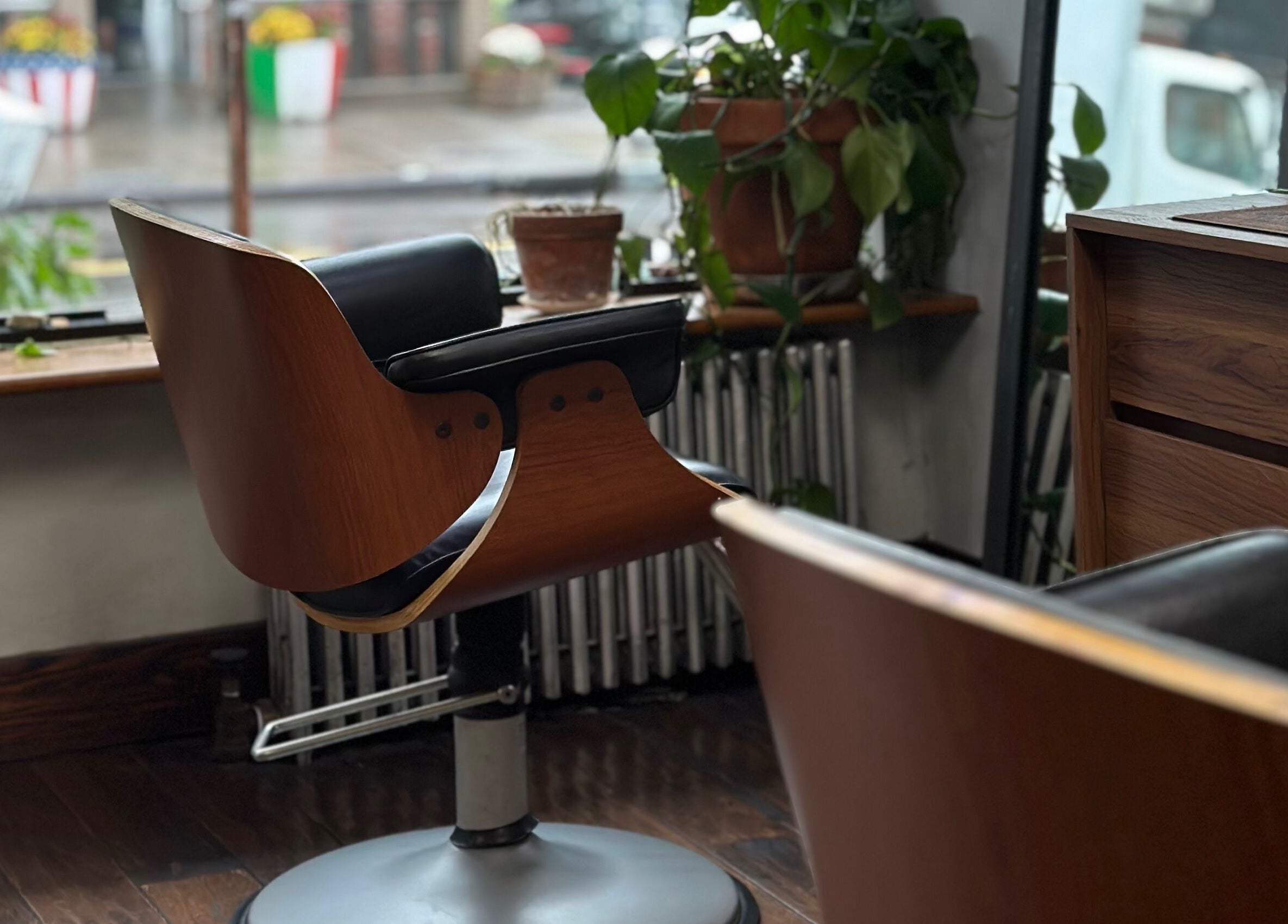 Modern salon chair at Roots Radicals Salon, New York, New York, US, with lush plants and wood decor.