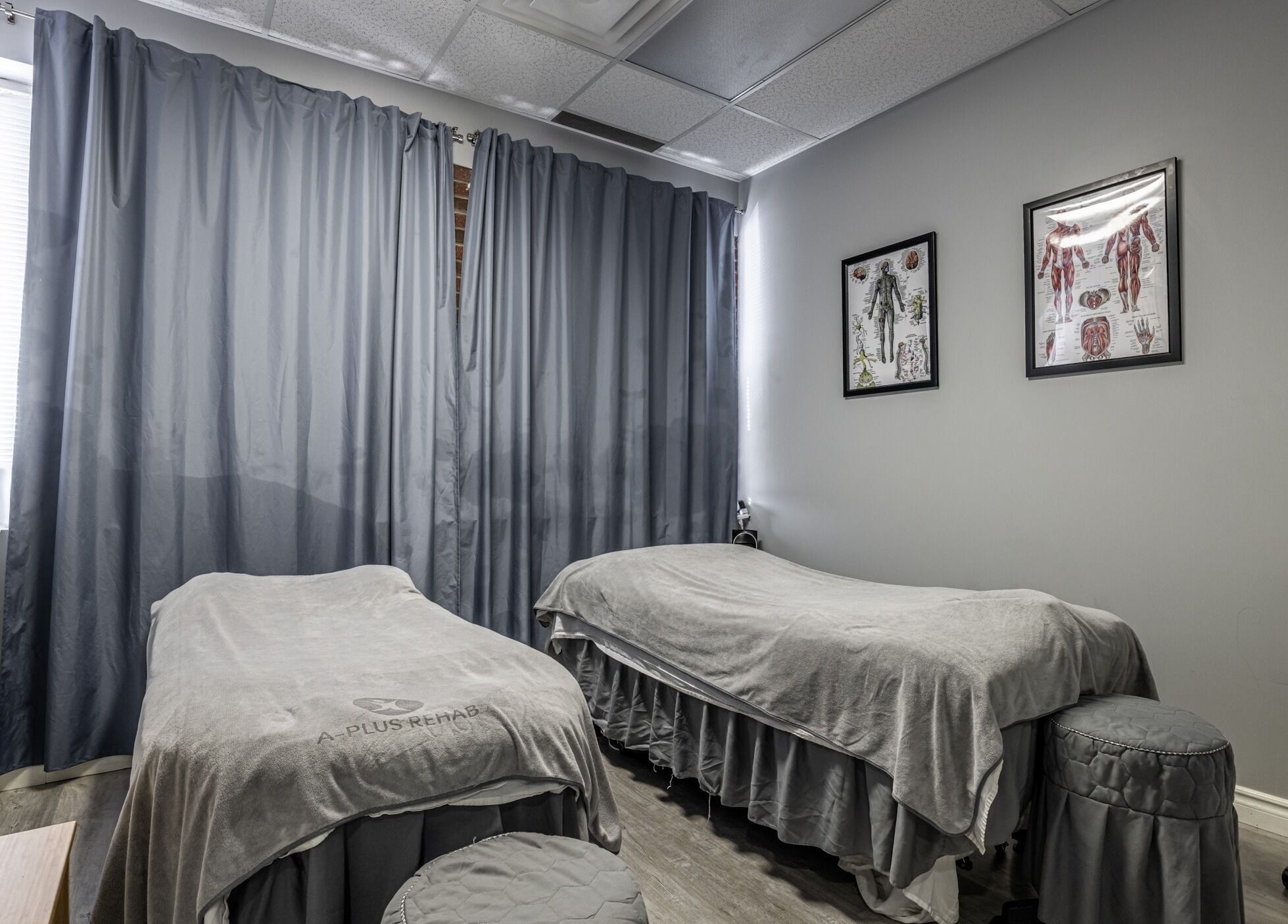 Cozy therapy room at A-Plus Rehab in Toronto, Ontario, CA, featuring massage tables and calming decor.