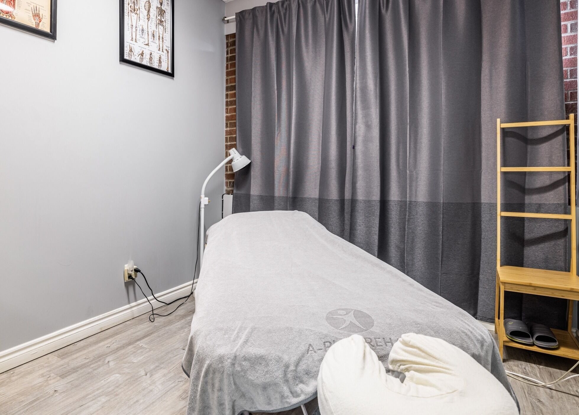 Relaxing massage room at A-Plus Rehab in Toronto, Ontario, CA, featuring a cozy treatment bed with soft lighting.