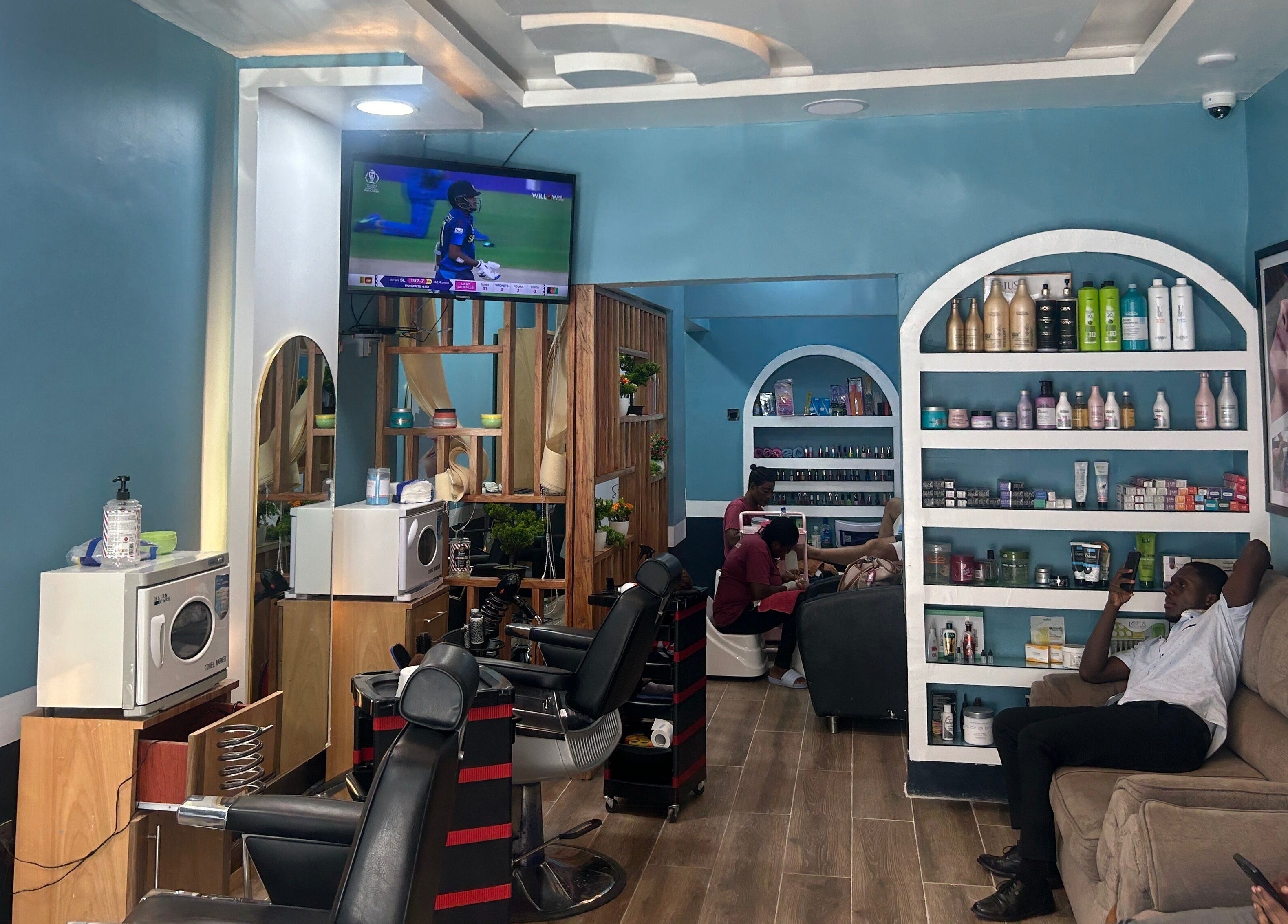 Relaxing interior of The Masters Cut Osu in Accra, Greater Accra Region, GH, featuring seating and salon products.