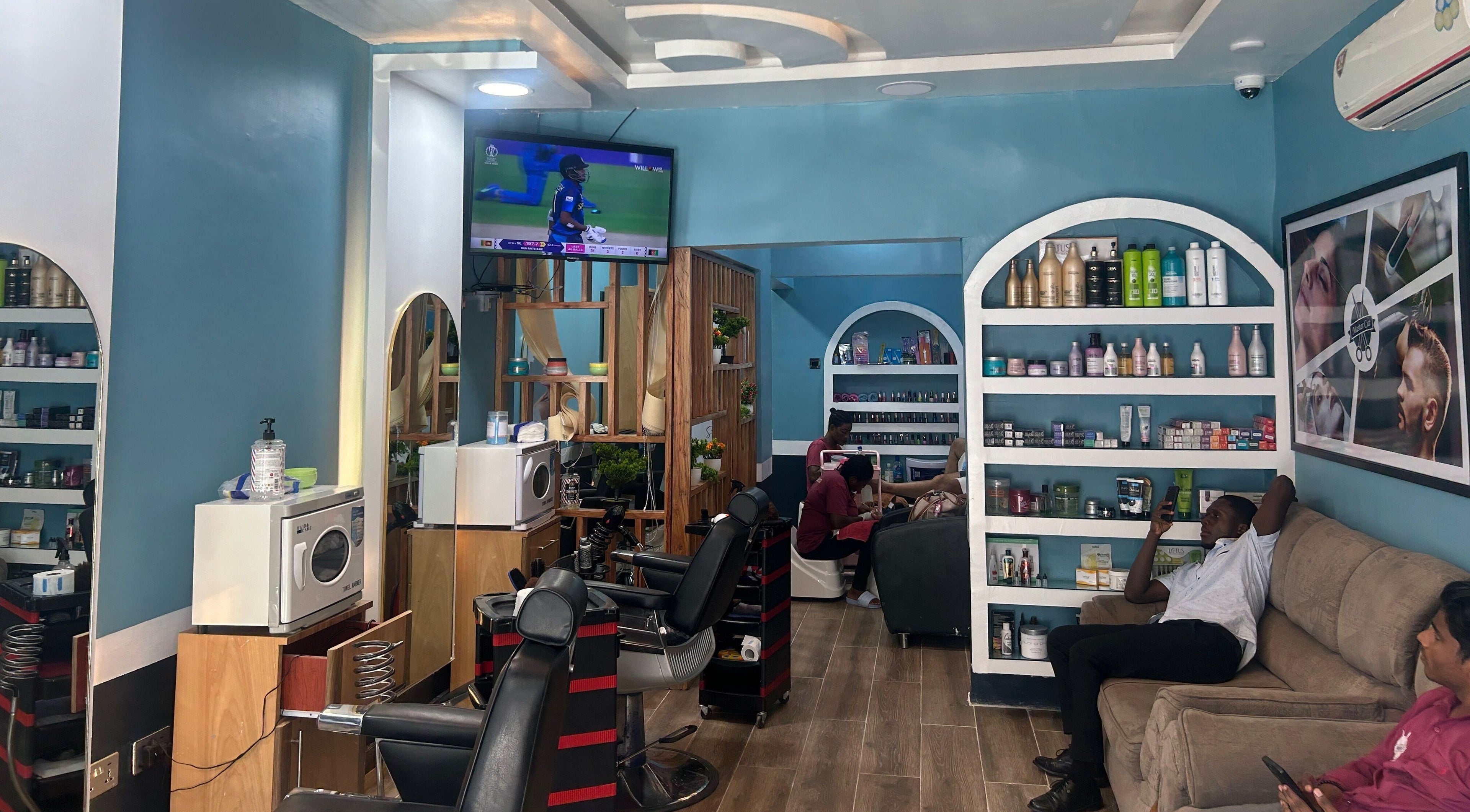 Relaxing interior of The Masters Cut Osu in Accra, Greater Accra Region, GH, featuring seating and salon products.