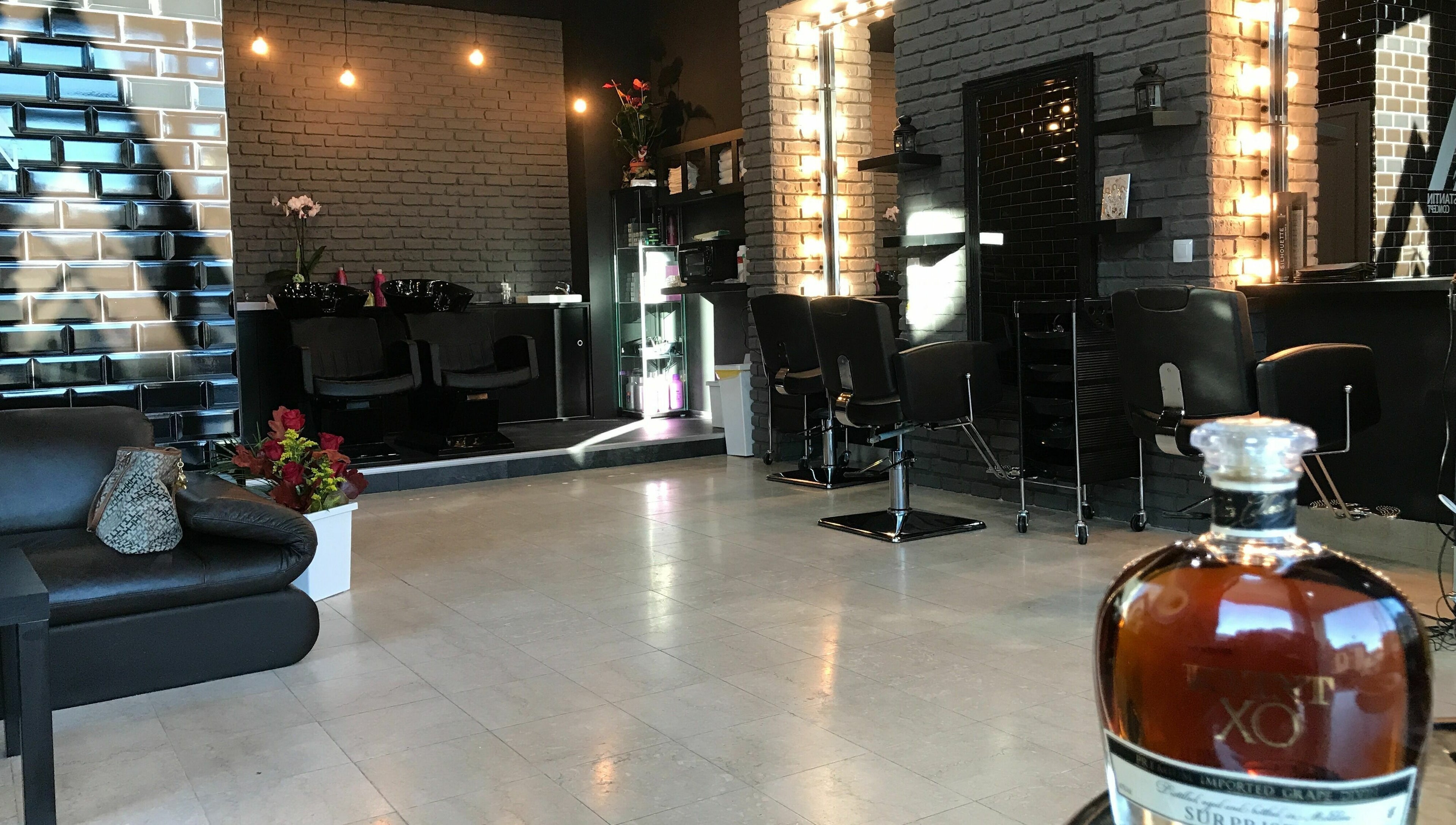 Interior elegant al Alex Constantin Concept, București, București, RO cu decor rafinat și scaune de coafură.