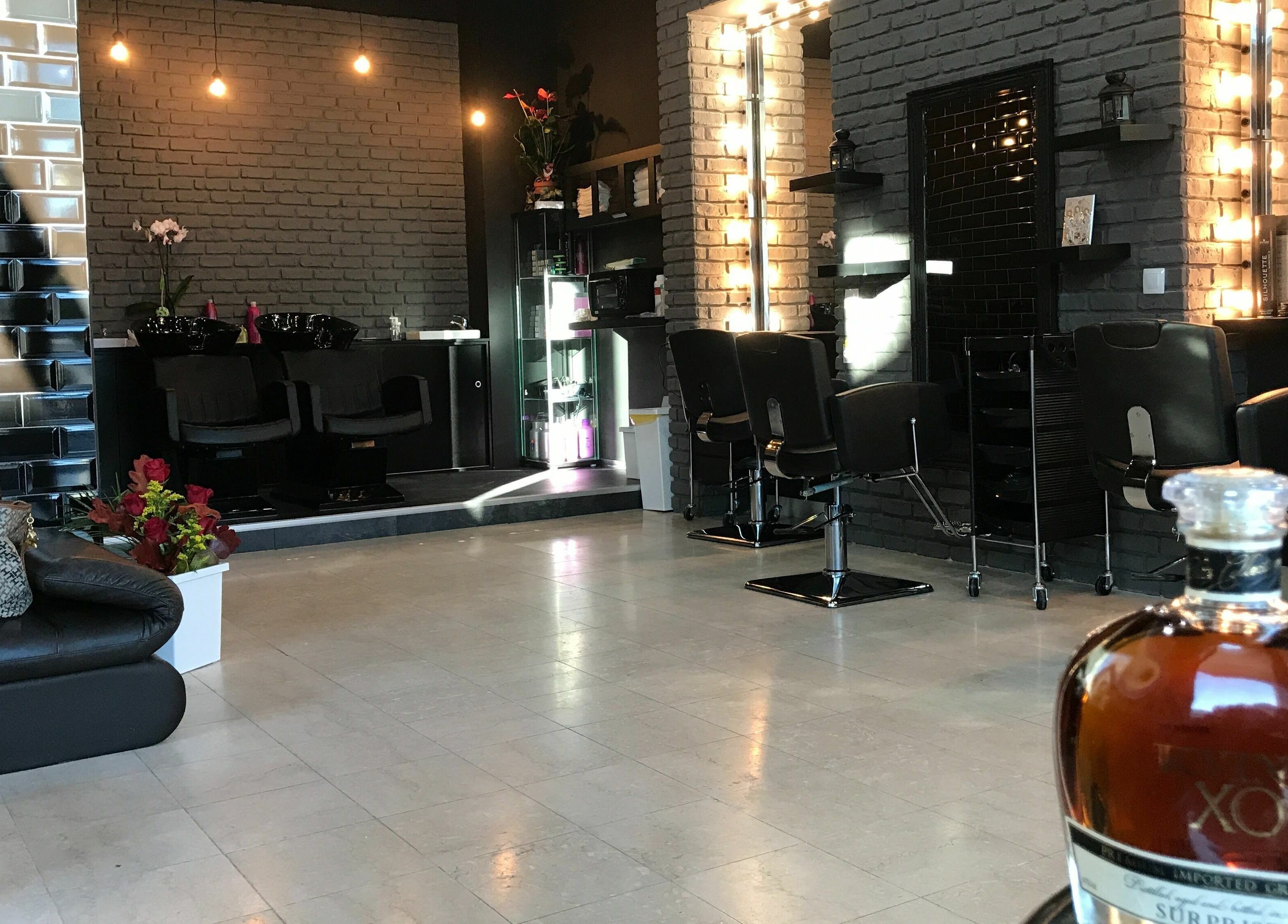 Interior elegant al Alex Constantin Concept, București, București, RO cu decor rafinat și scaune de coafură.