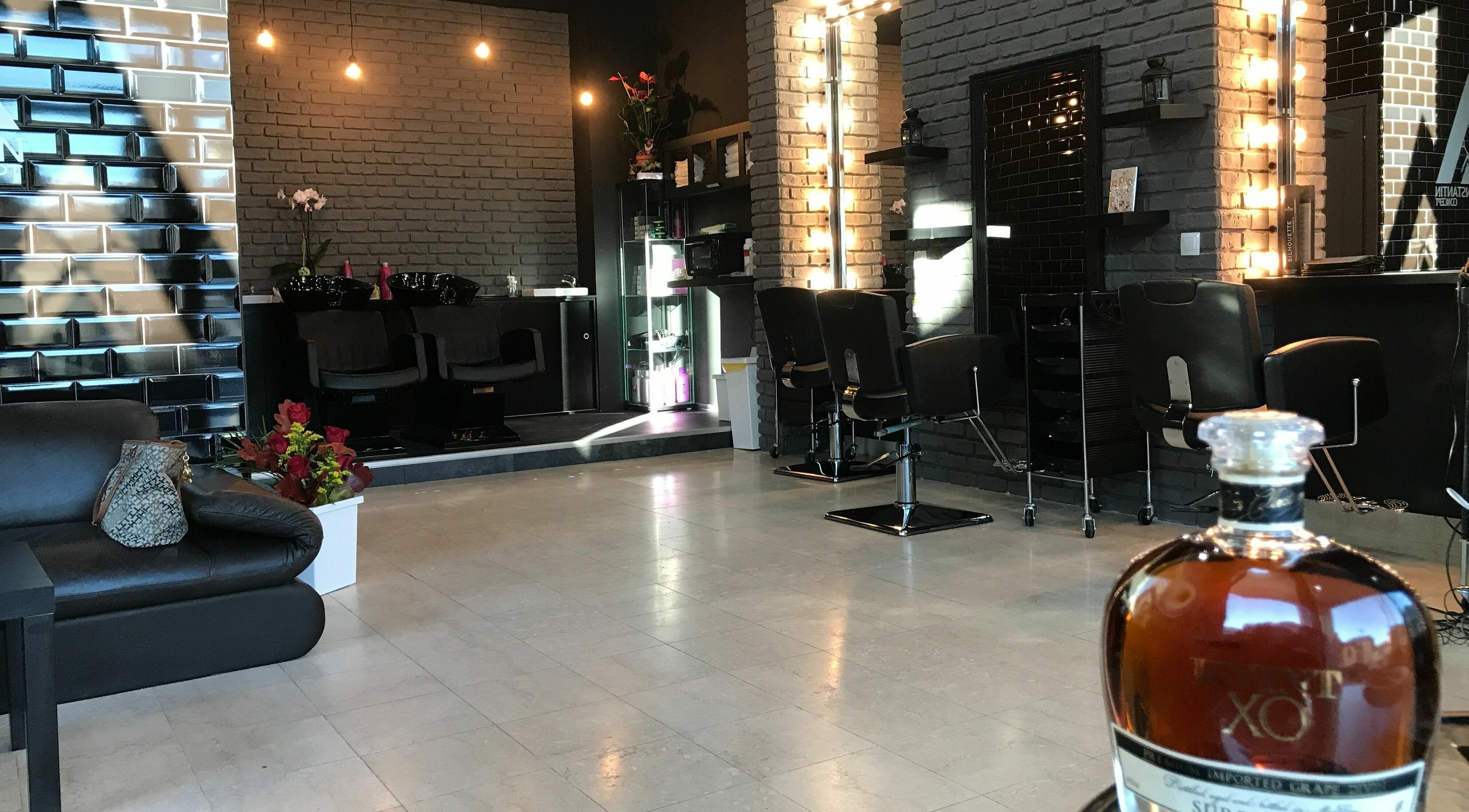 Interior elegant al Alex Constantin Concept, București, București, RO cu decor rafinat și scaune de coafură.