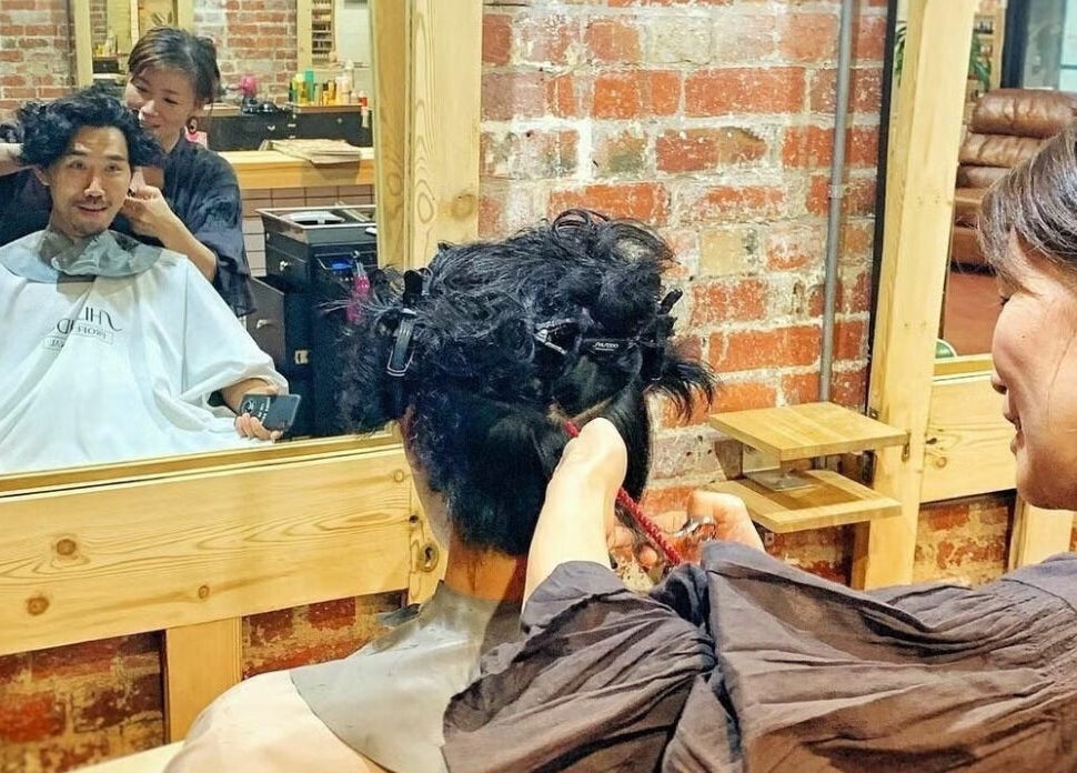 Stylist cutting client's hair at Salon Atreve, Melbourne, VIC, AU. Vibrant salon scene with engaging service.