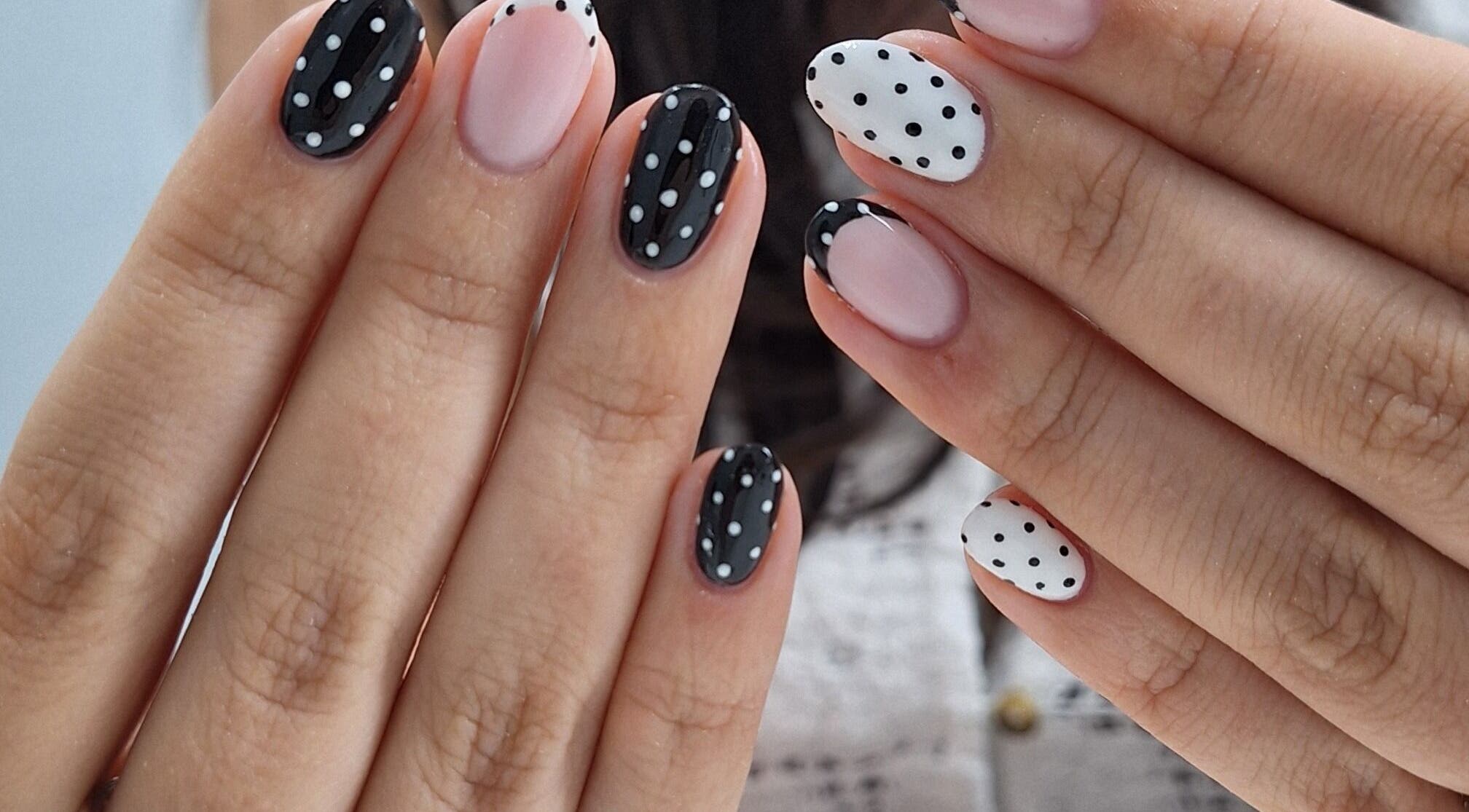 Chic polka dot nail art at Nails Quoture, Glasgow, Scotland, GB. Elegant black and white manicure design.
