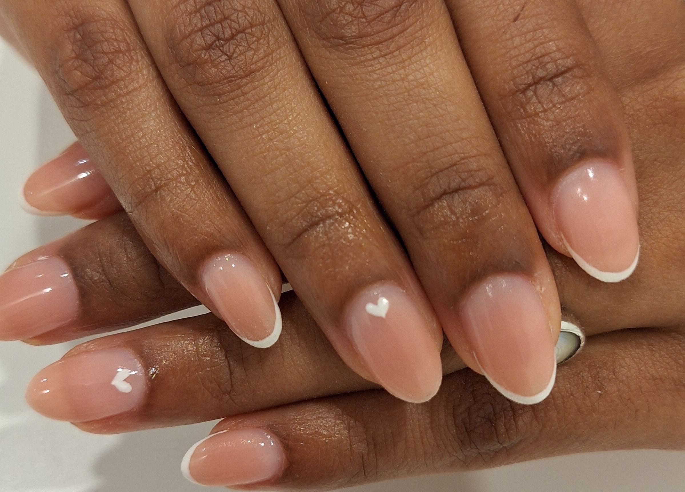 Elegant French manicure with white heart design at Nails Quoture, Glasgow, Scotland, GB.
