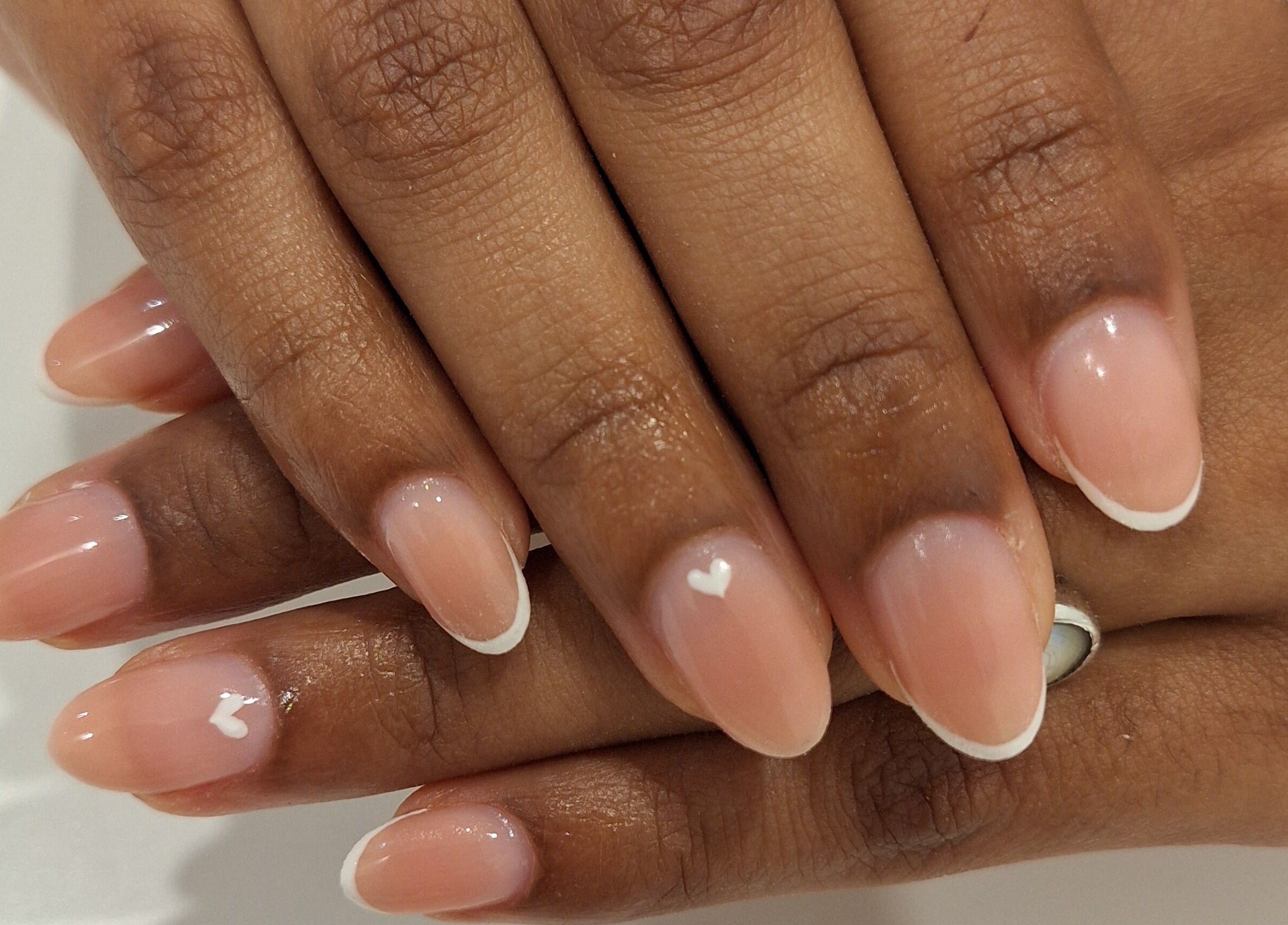 Elegant French manicure with white heart design at Nails Quoture, Glasgow, Scotland, GB.