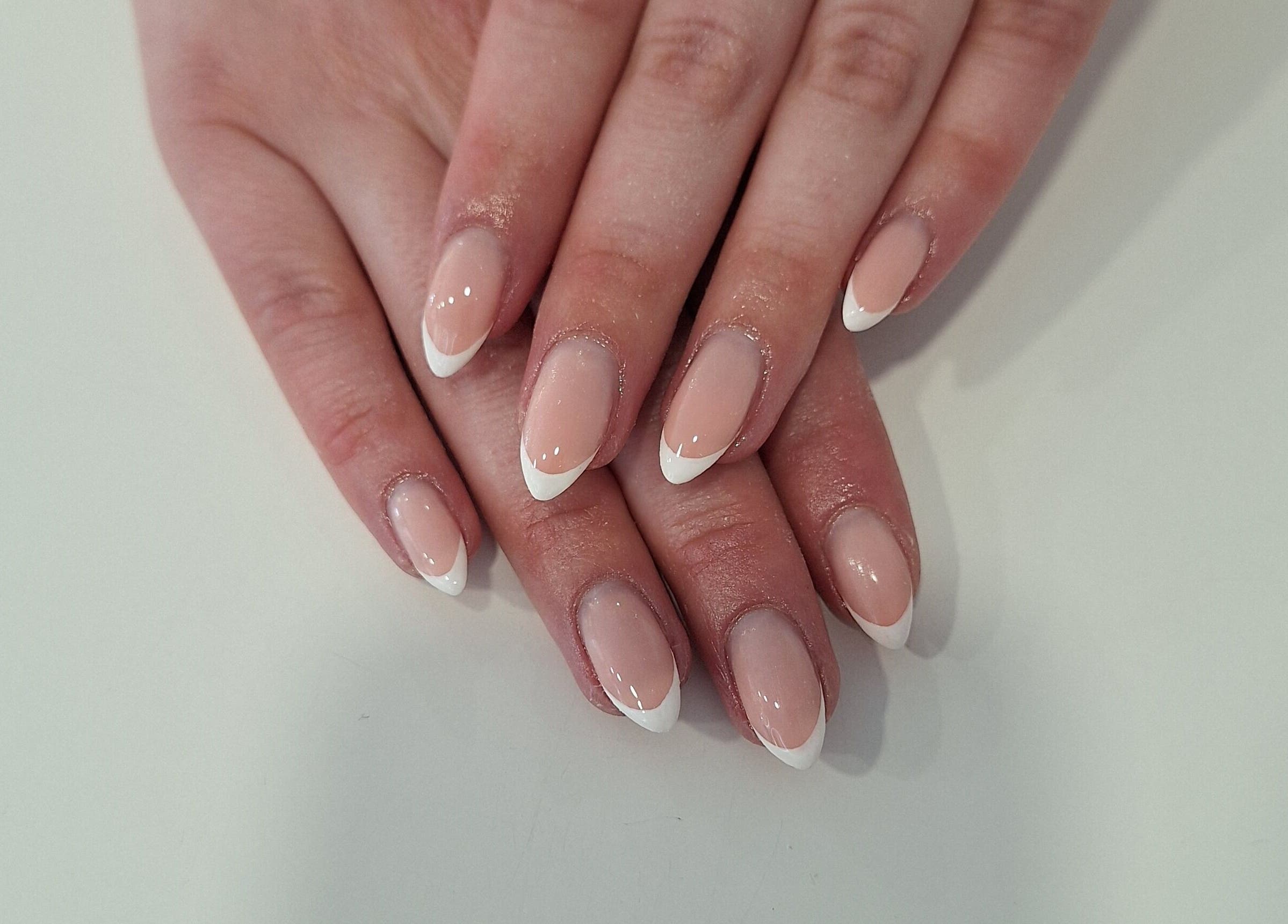 Stylish French manicure at Nails Quoture in Glasgow, Scotland, GB showcasing elegant white tips on natural nails.