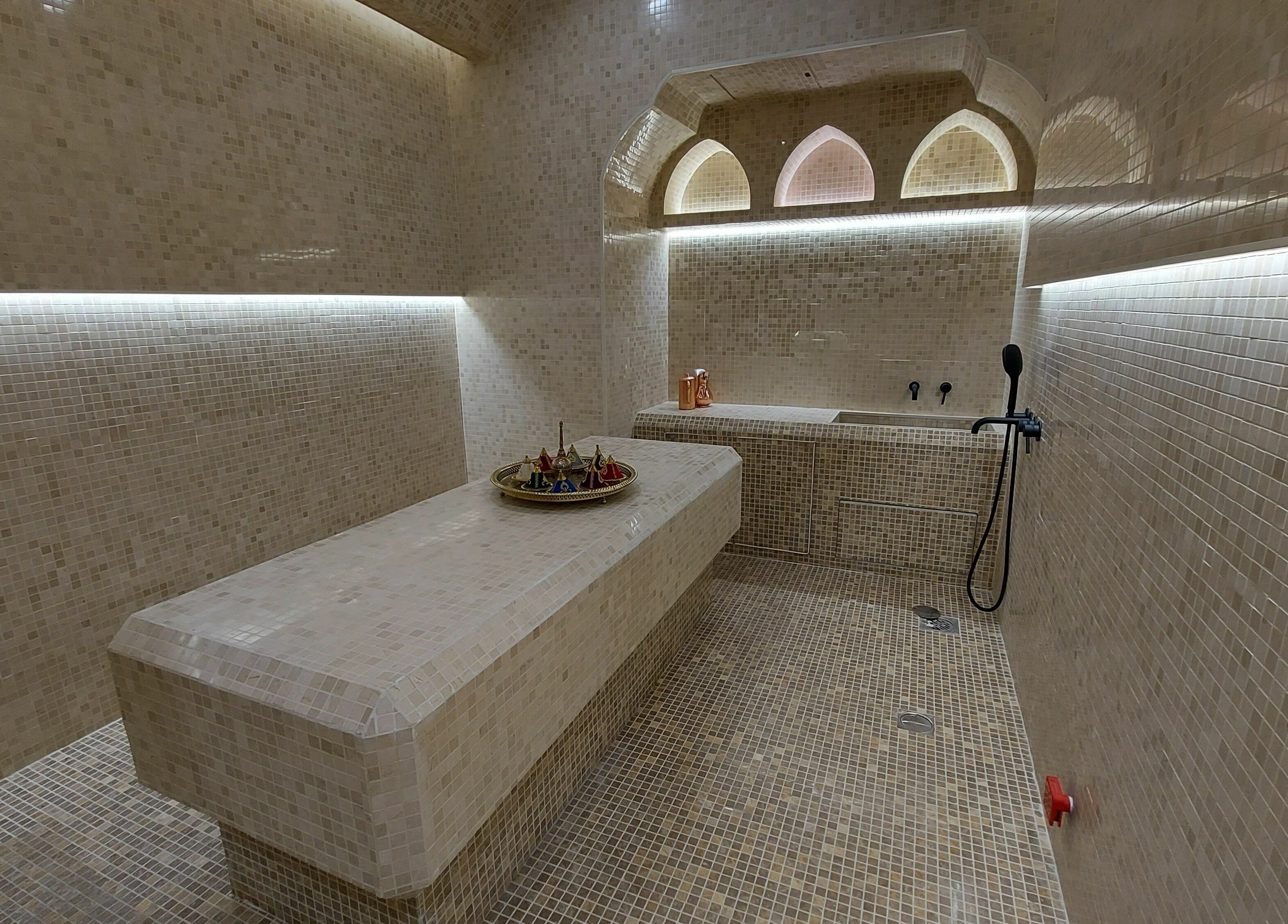 Luxurious spa room at Cabello Lounge Femme Ladies Salon, Dubai, AE, with elegant mosaic tiles and ambient lighting.