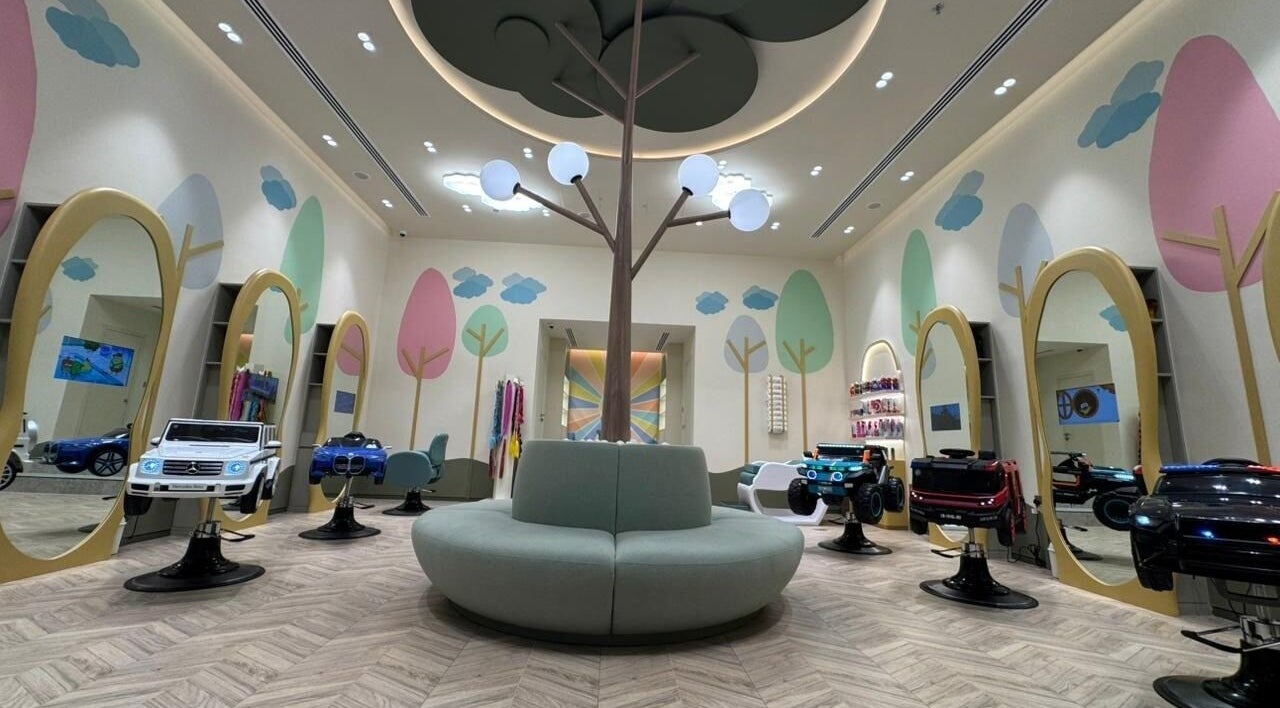 Playful children's salon at Kido By Cabello, Dubai, Dubai, AE featuring colorful decor and unique car-themed chairs.