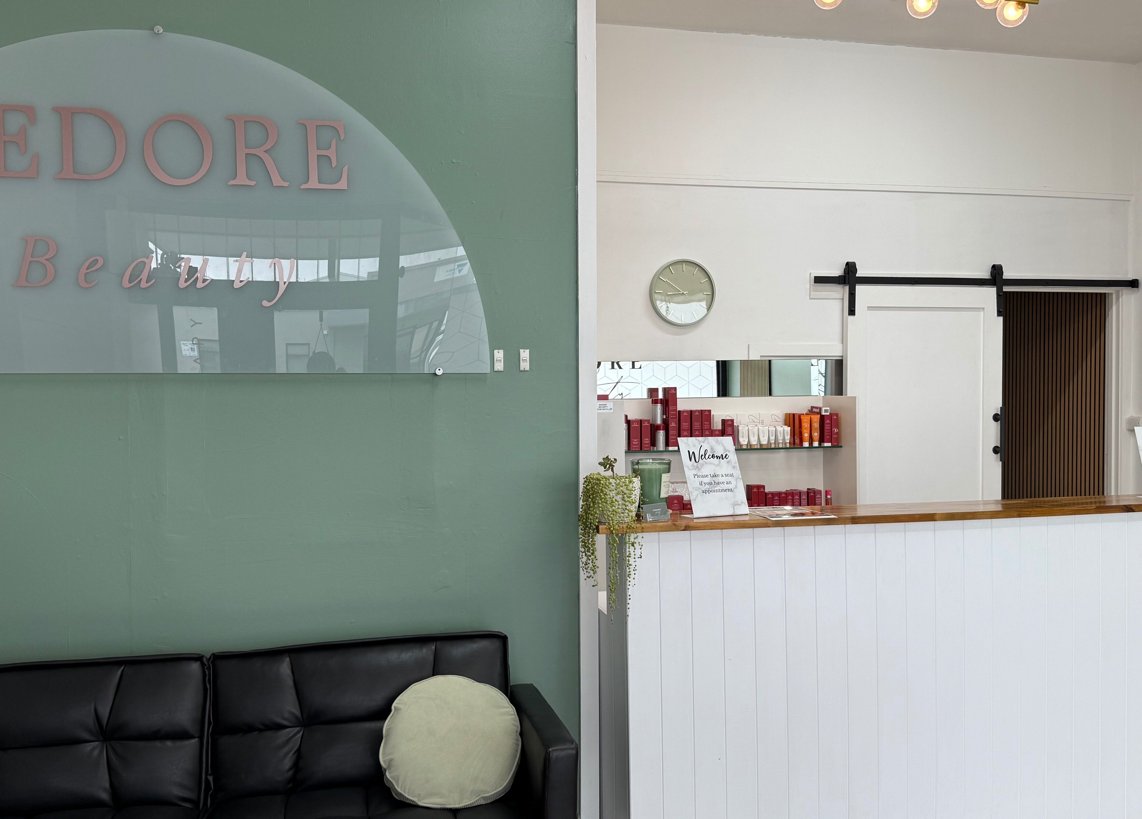 Reception area of Jedore Beauty in Portland, Victoria, AU, featuring a comfy black sofa and a welcoming counter.