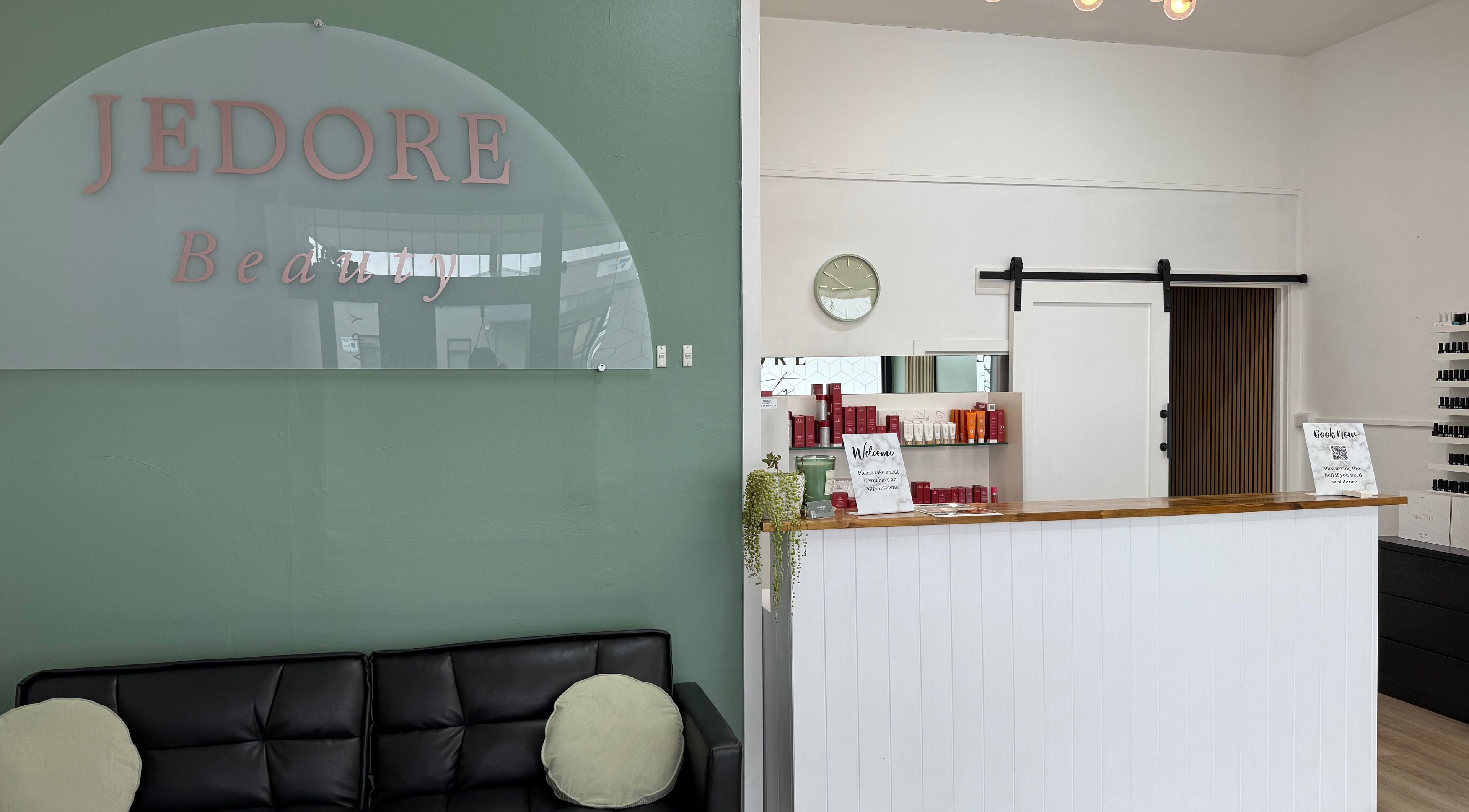Reception area of Jedore Beauty in Portland, Victoria, AU, featuring a comfy black sofa and a welcoming counter.