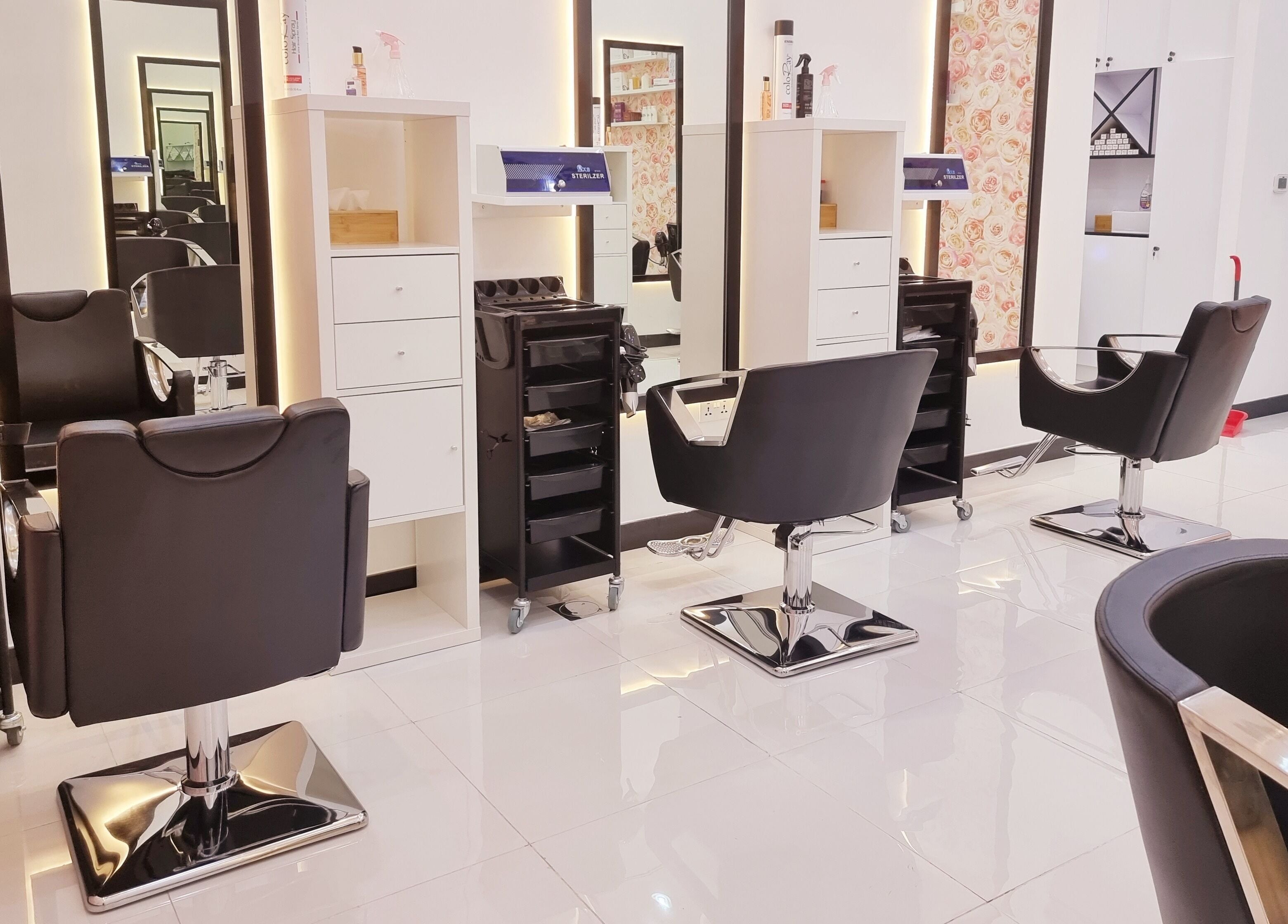 Elegant styling stations at Ombre Salon for Ladies LLC, Dubai, AE, featuring modern black salon chairs.